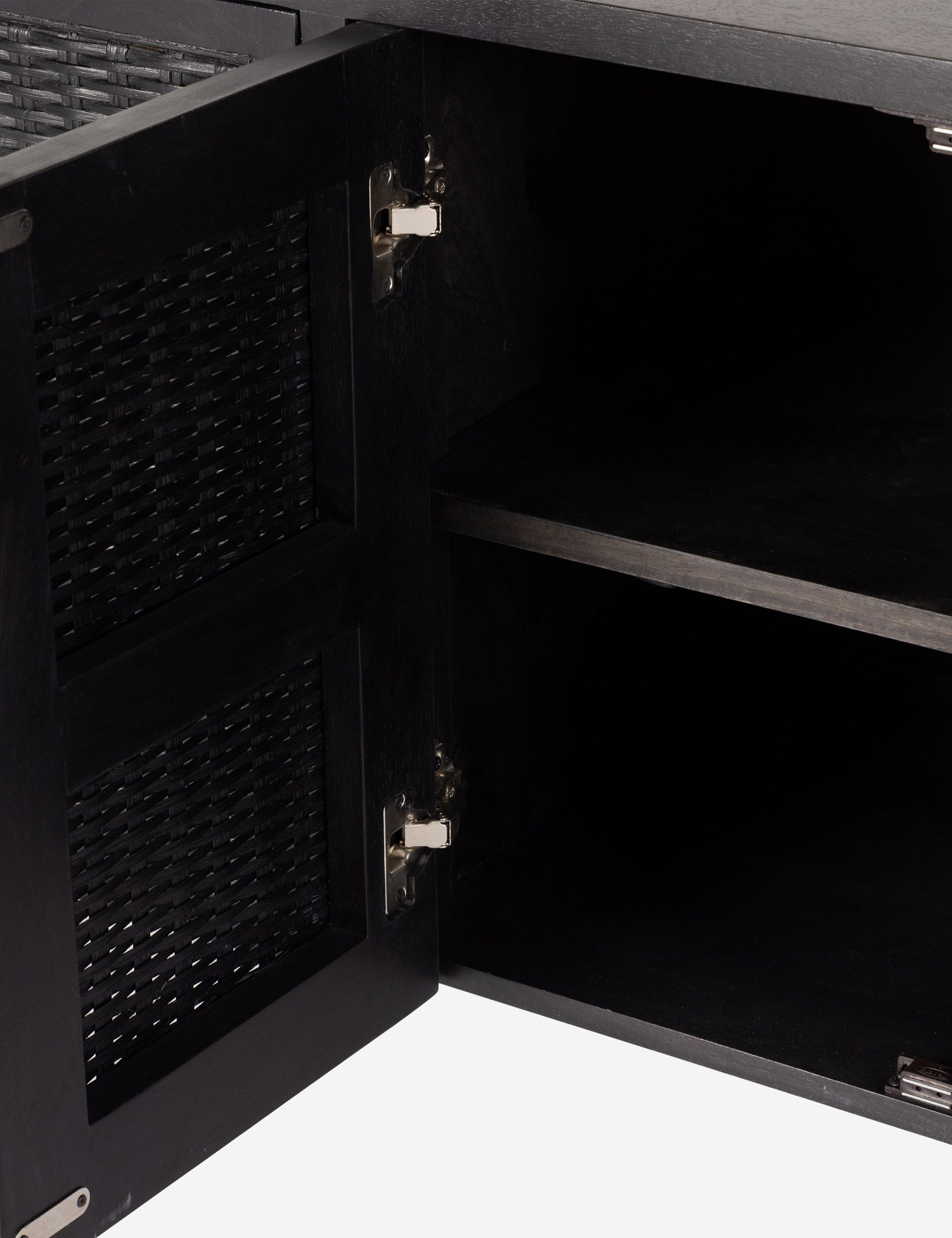 Open door of the Isaura black cane-paneled media console.