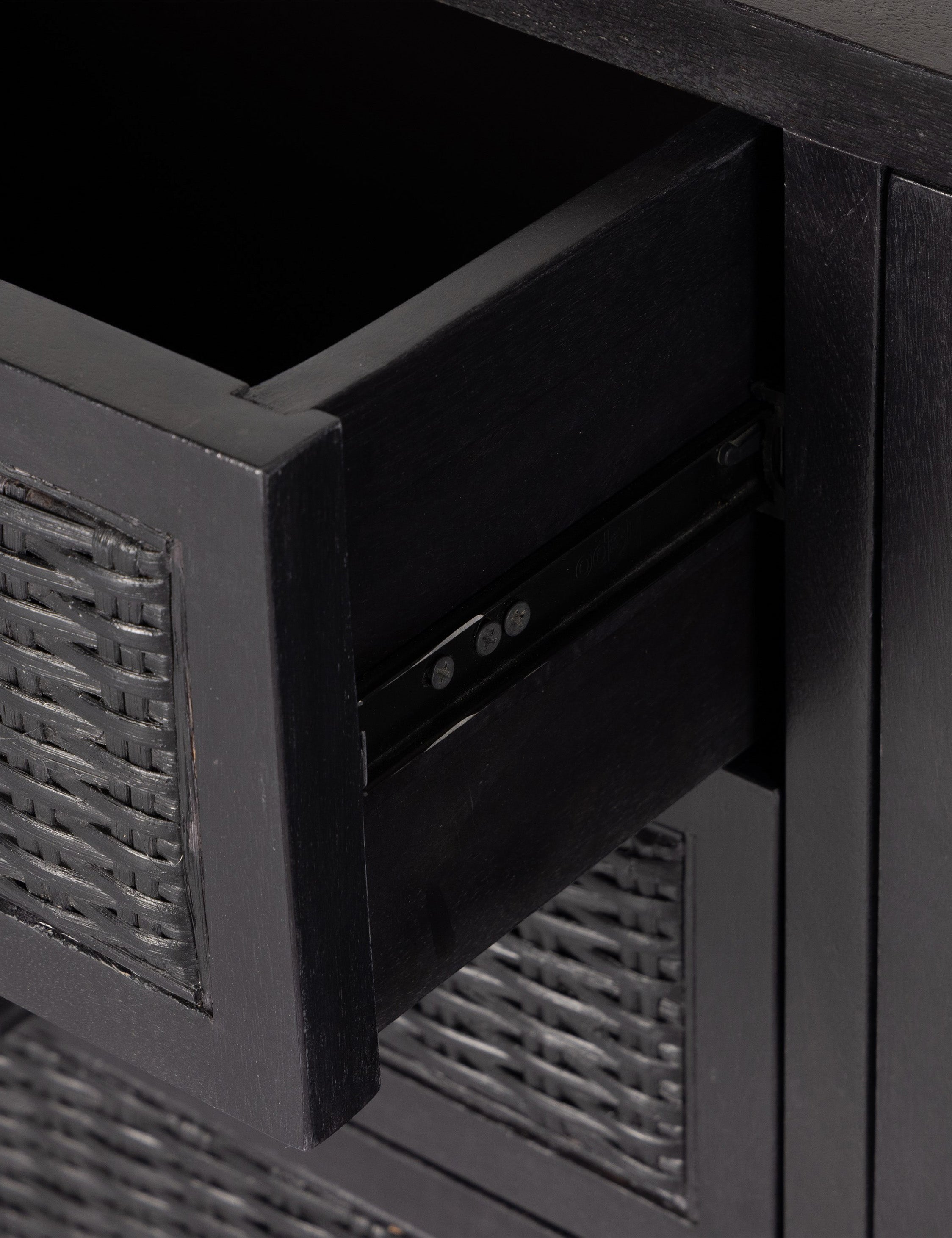 Drawer of the Isaura black cane-paneled media console.