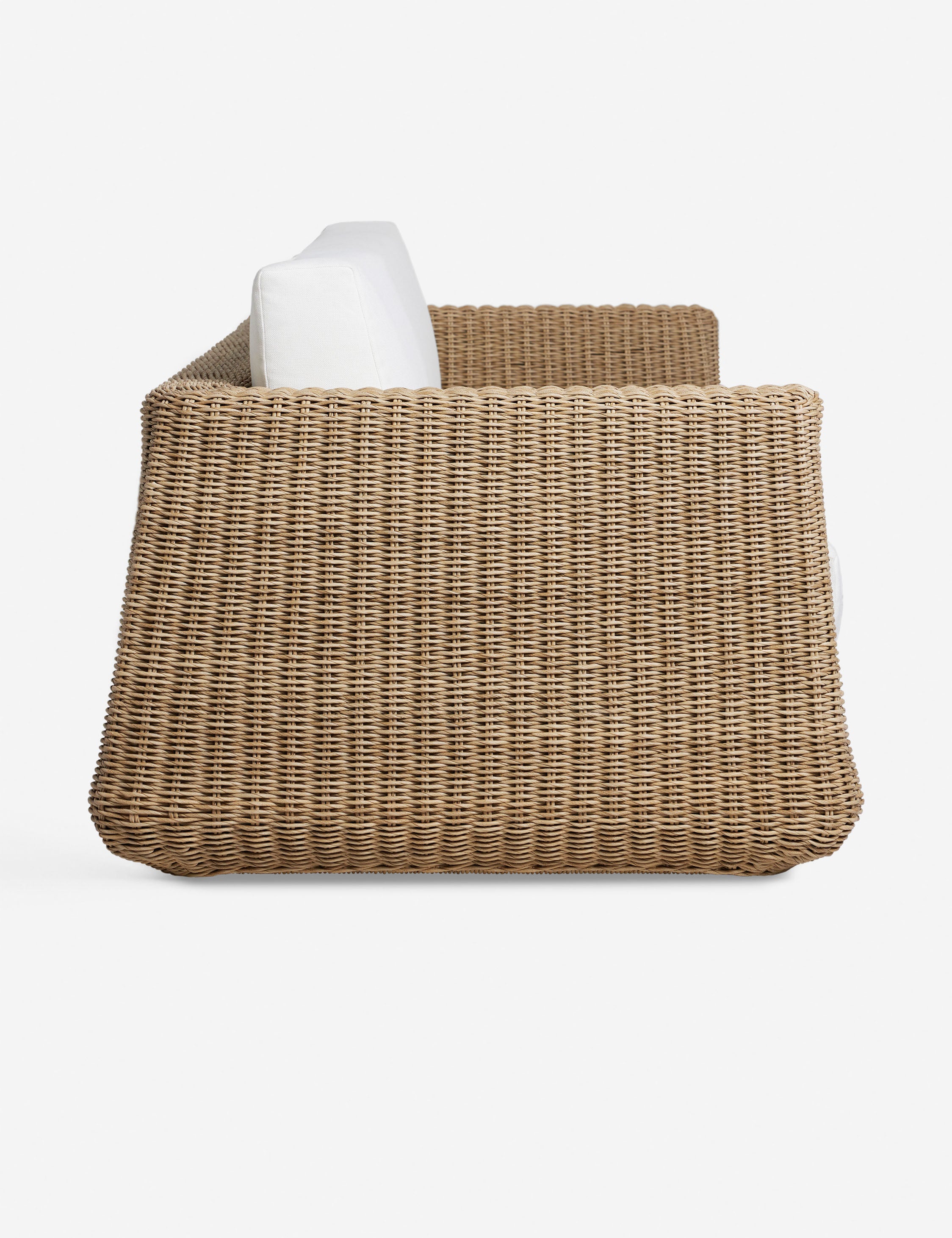 Side profile of the Aisha wide arm modern wicker outdoor sofa.