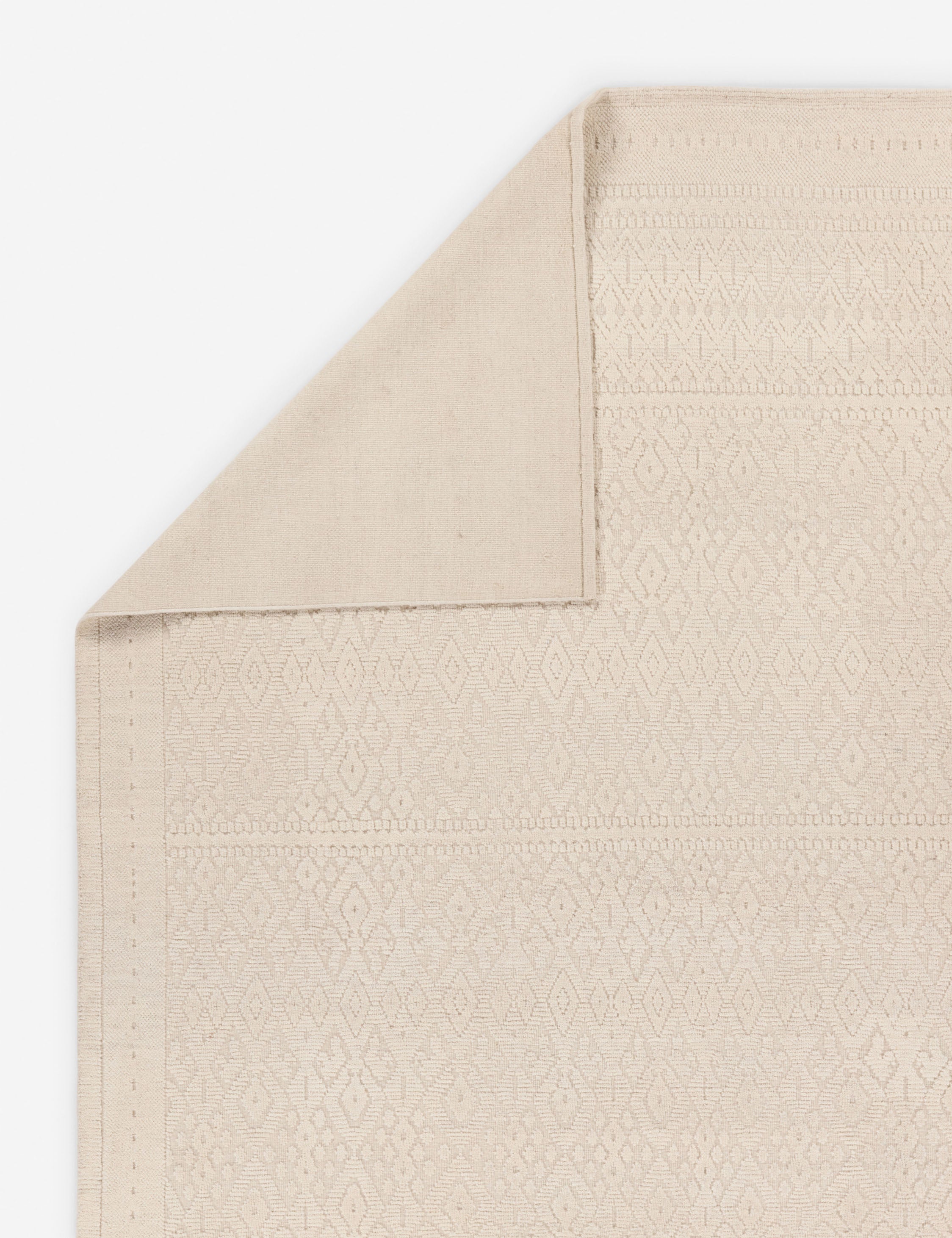Folded corner showing the back of the Pavan moroccan-inspired hand-knotted wool rug.