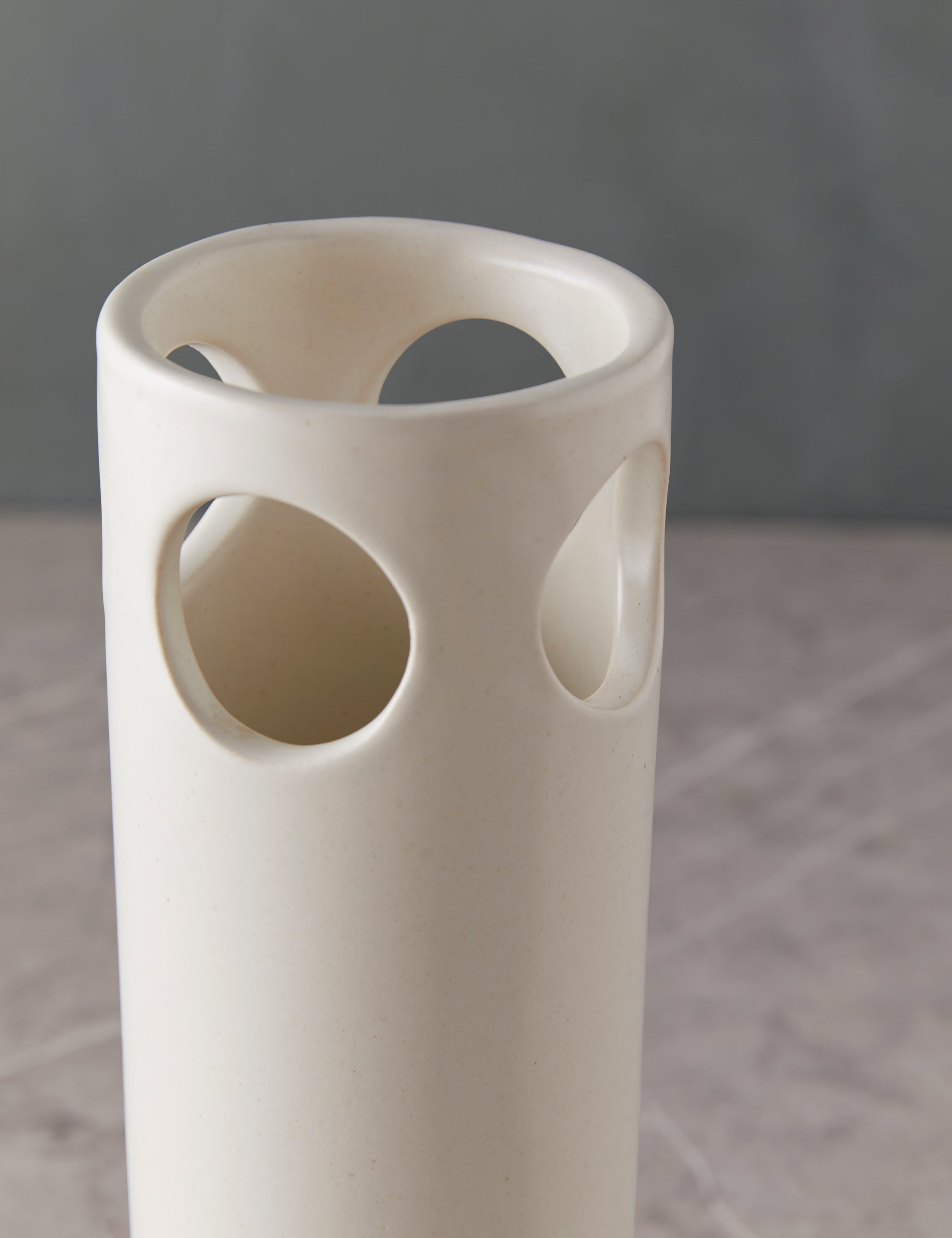 Close up view of the tall ceramic Cenote Vase by SIN Ceramics in white