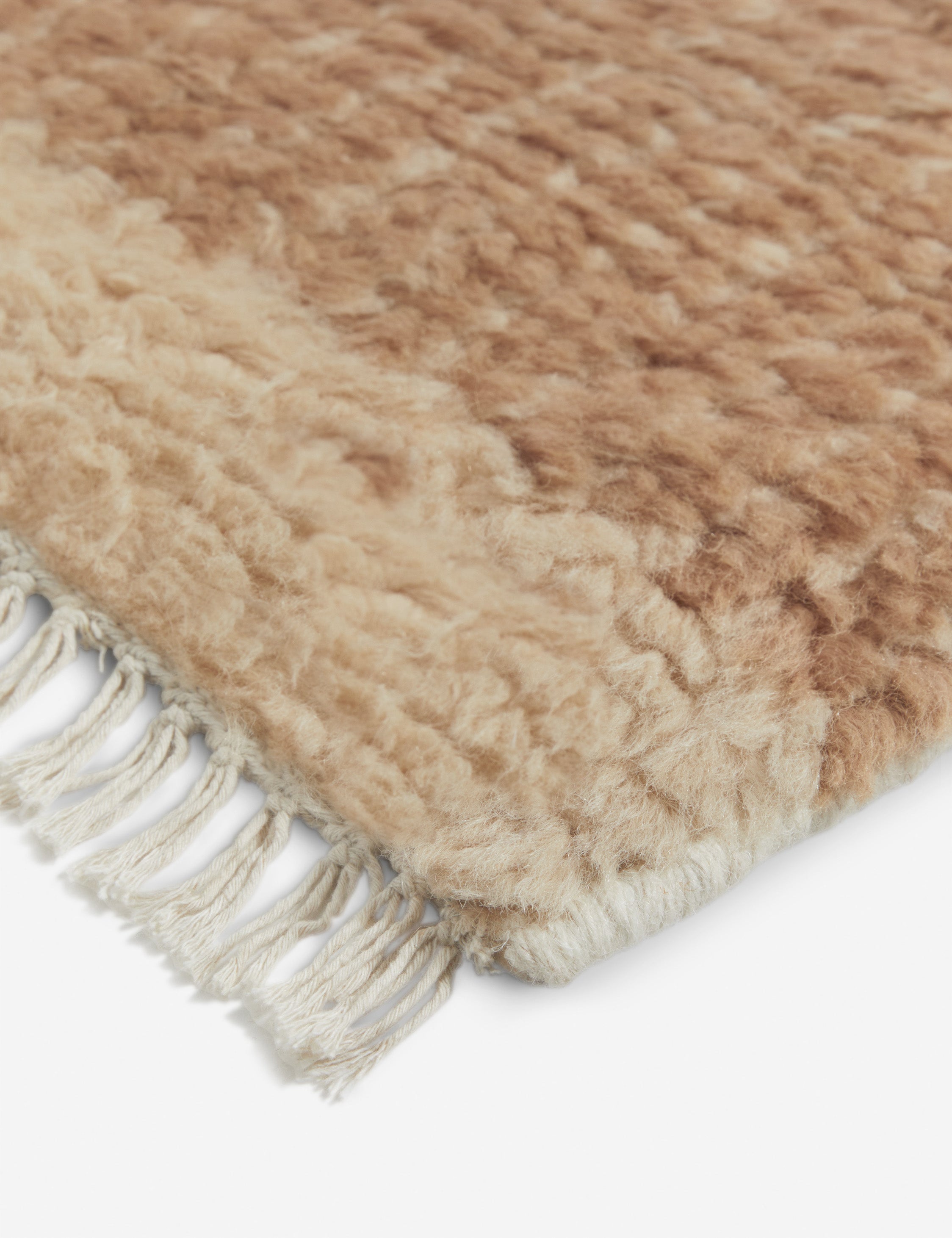 Close up of the corner of the Cyprus striped, tasseled, Moroccan-styled wool rug.