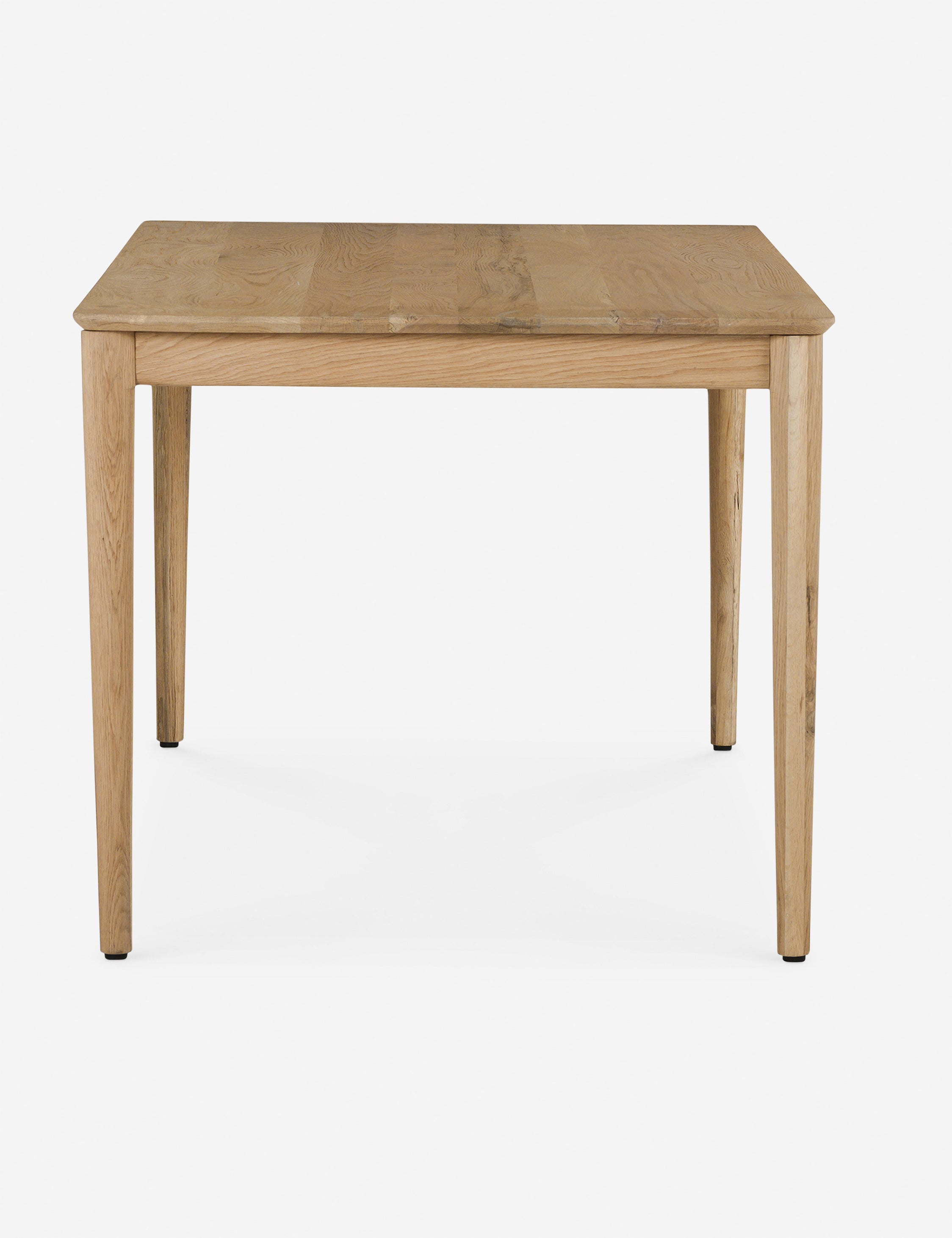 Side profile of the Lussier natural oak tapered leg dining table