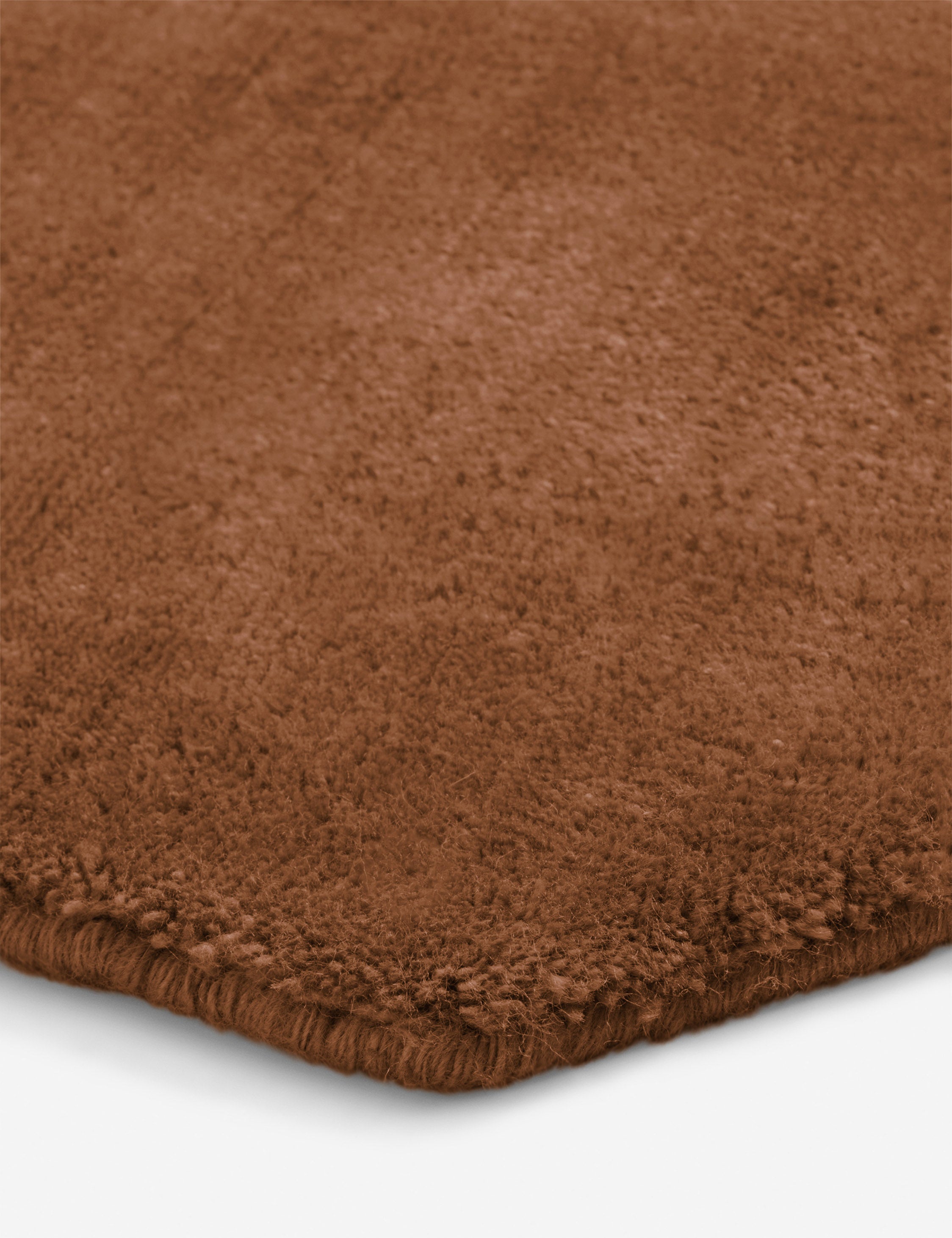 Close up of the corner of the Damara solid viscose rug in rose.