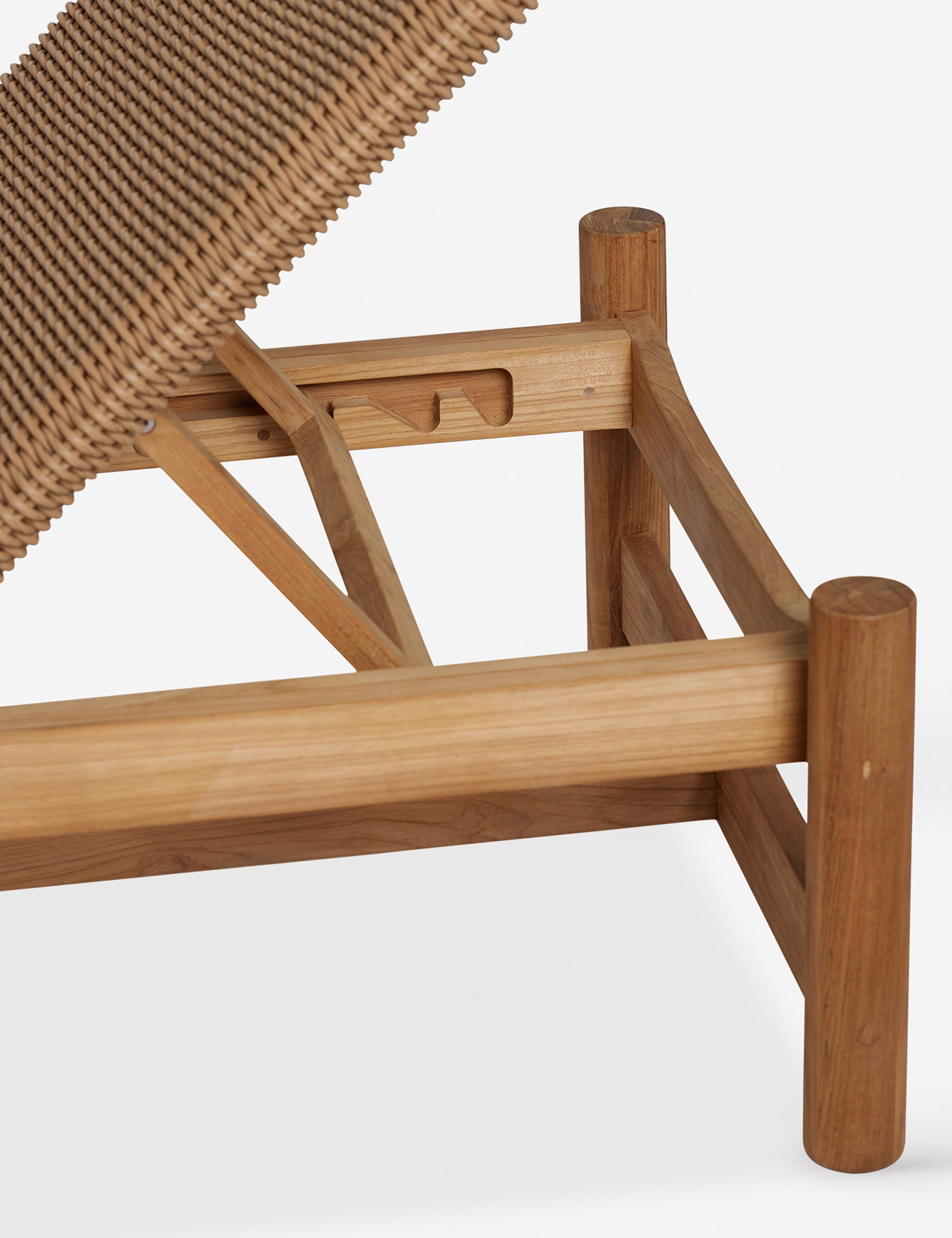 Close up off the frame of the Gally wicker and teak outdoor chaise.