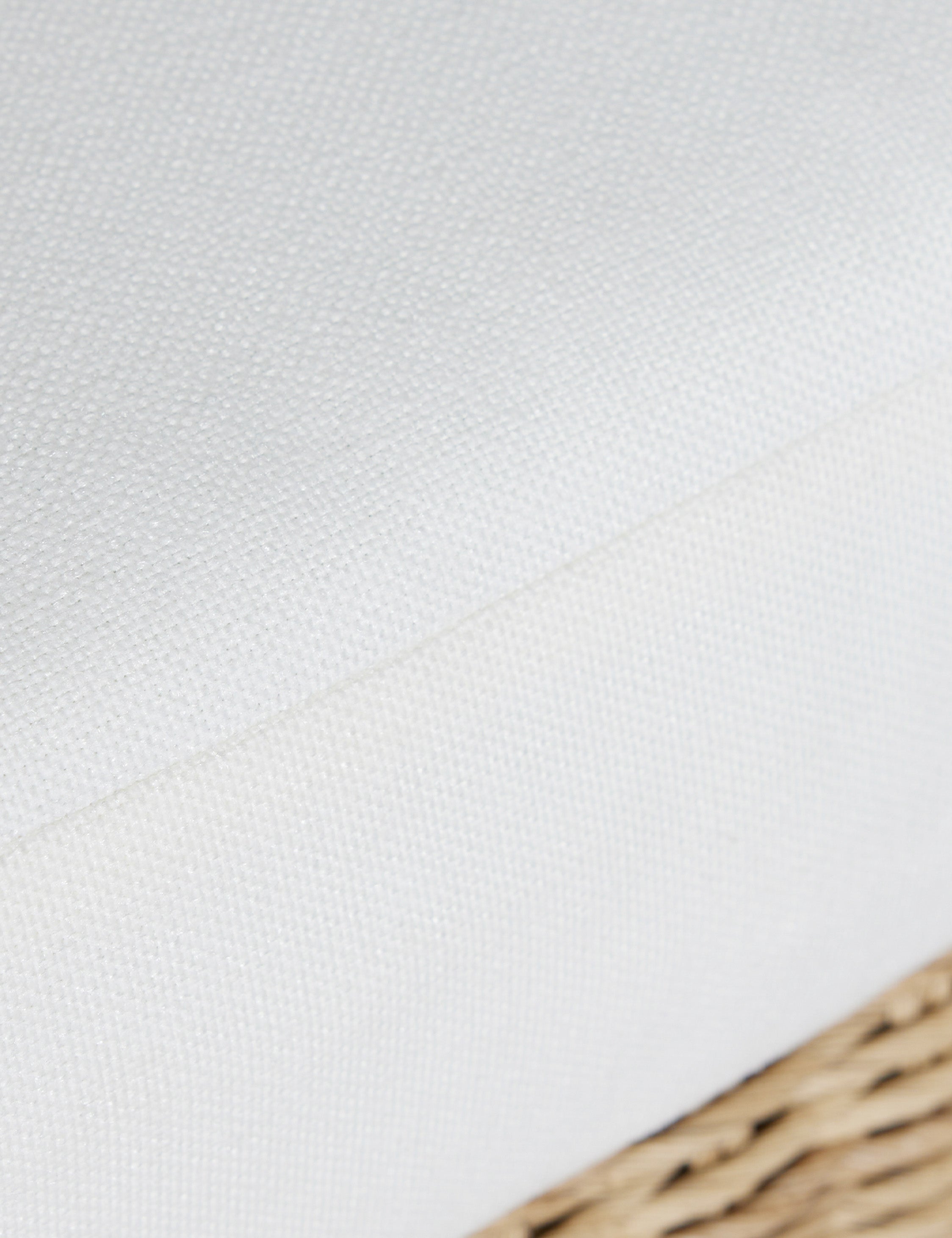 Close up of the seat cushion of the Hadler modern sculptural open frame wicker outdoor accent chair.