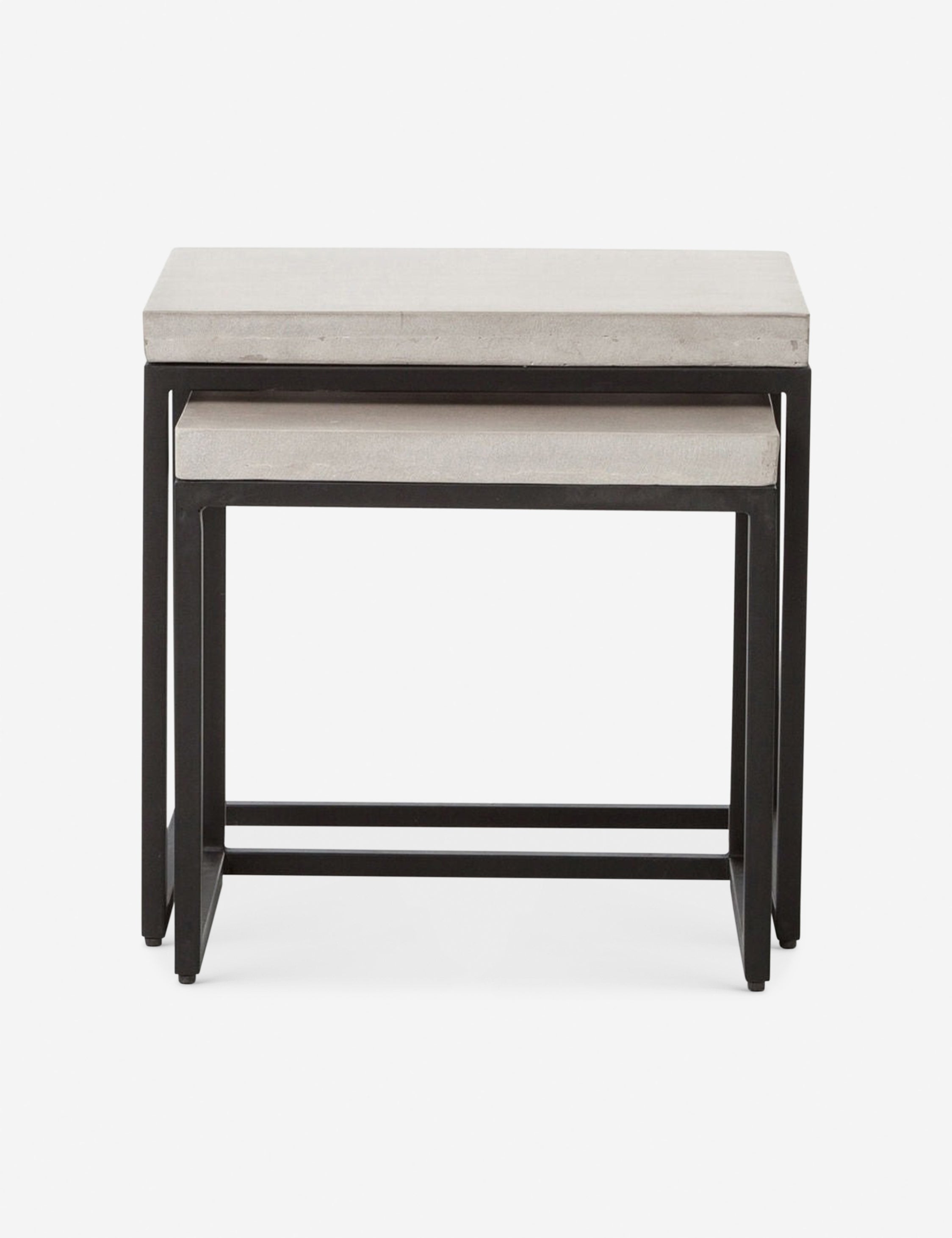 The Kallia indoor and outdoor nesting side tables with iron bases and concrete tops with the smaller table half nested into the bigger table
