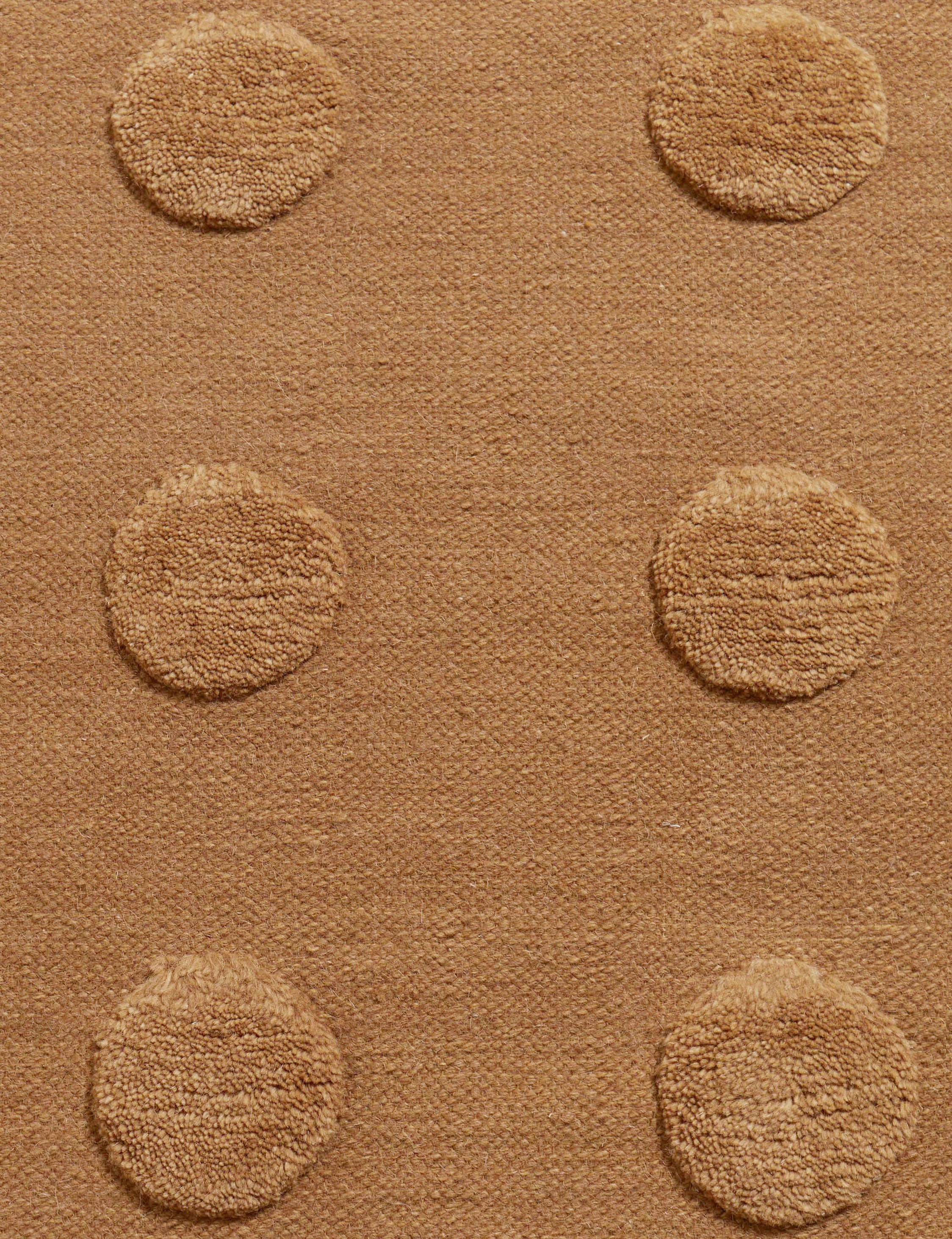 Close up of the Kohta high-low pile dot design wool area rug in camel