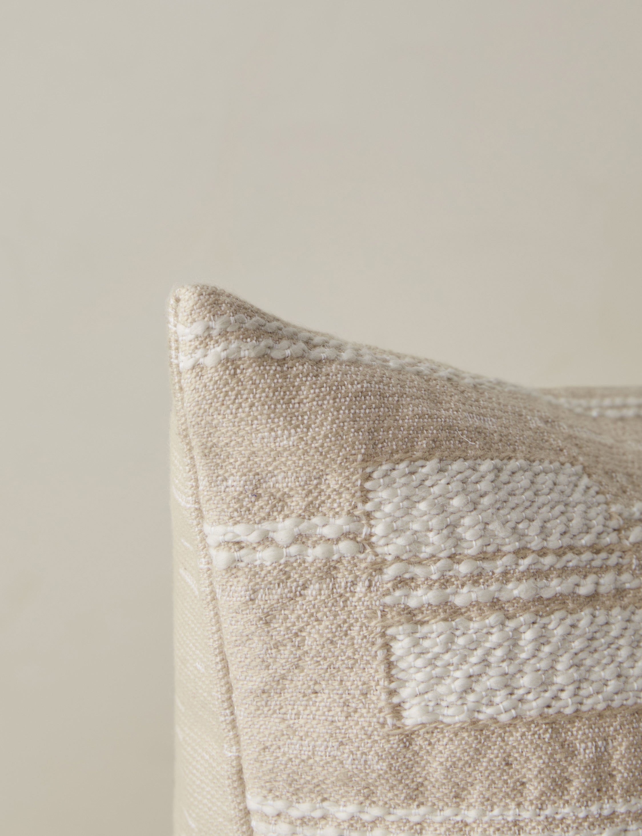 Corner of the Leighton broken stripe pillow in natural.