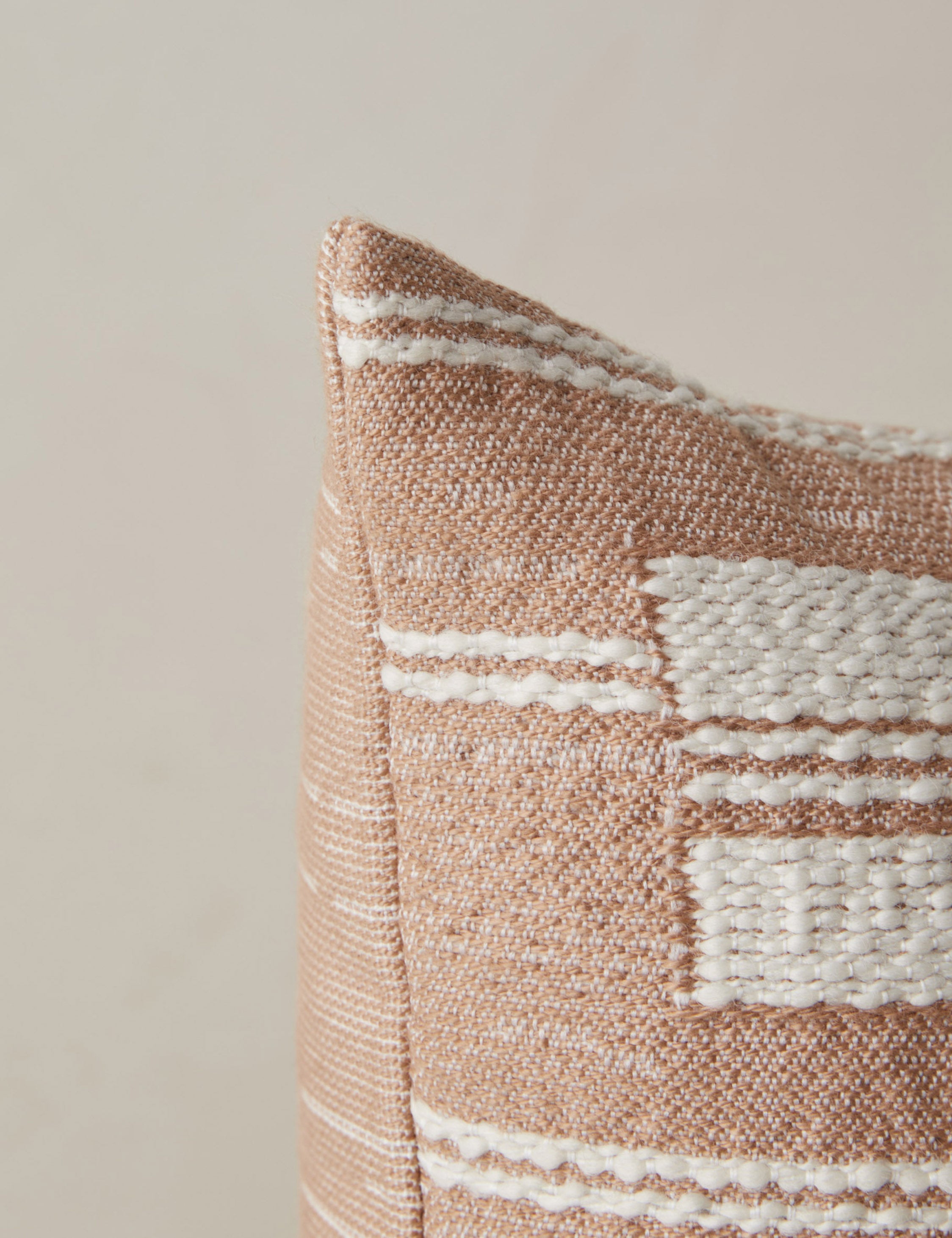 Corner of the Leighton broken stripe pillow in terracotta.