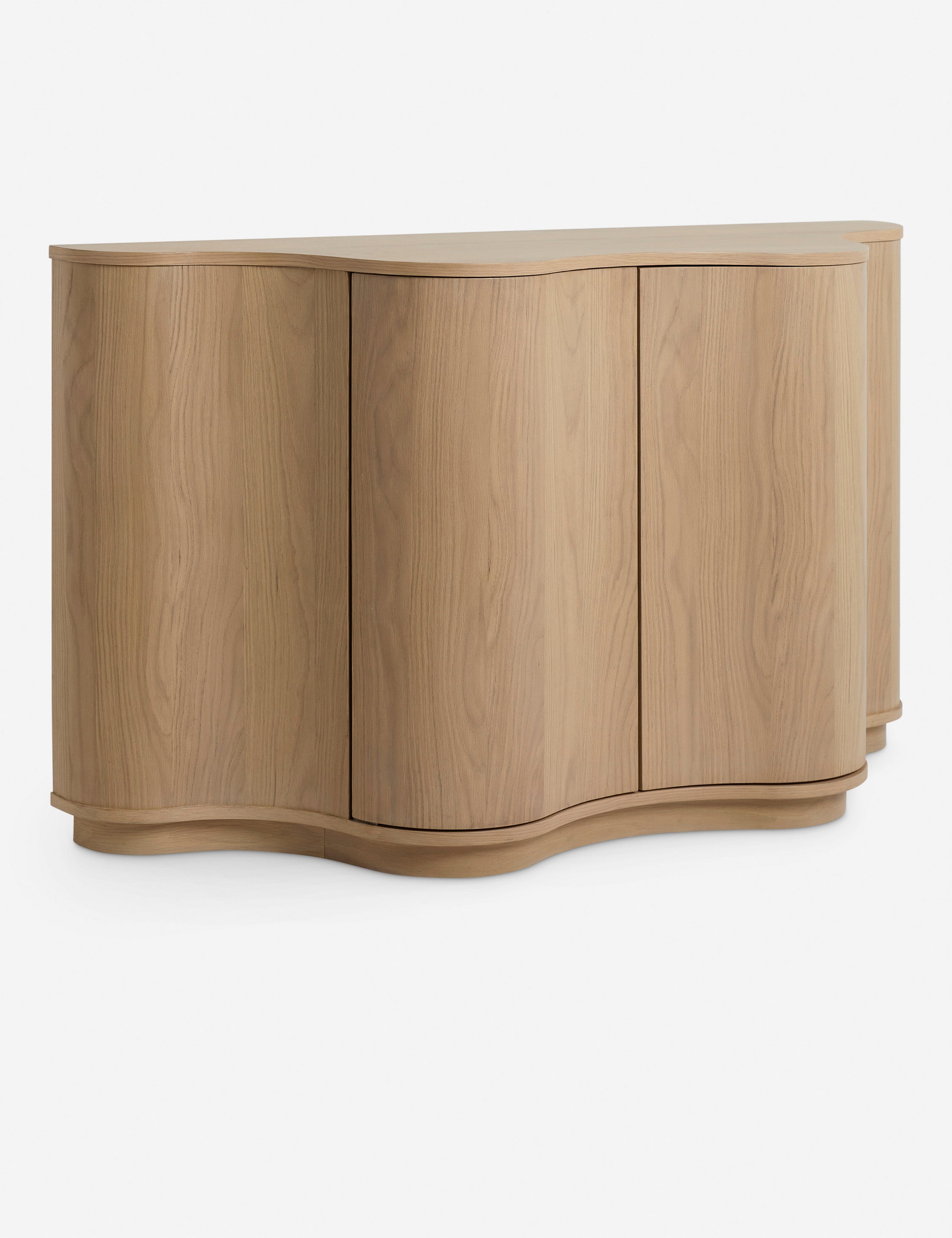 Angled view of the Cora half-moon, wavy light-wood sideboard