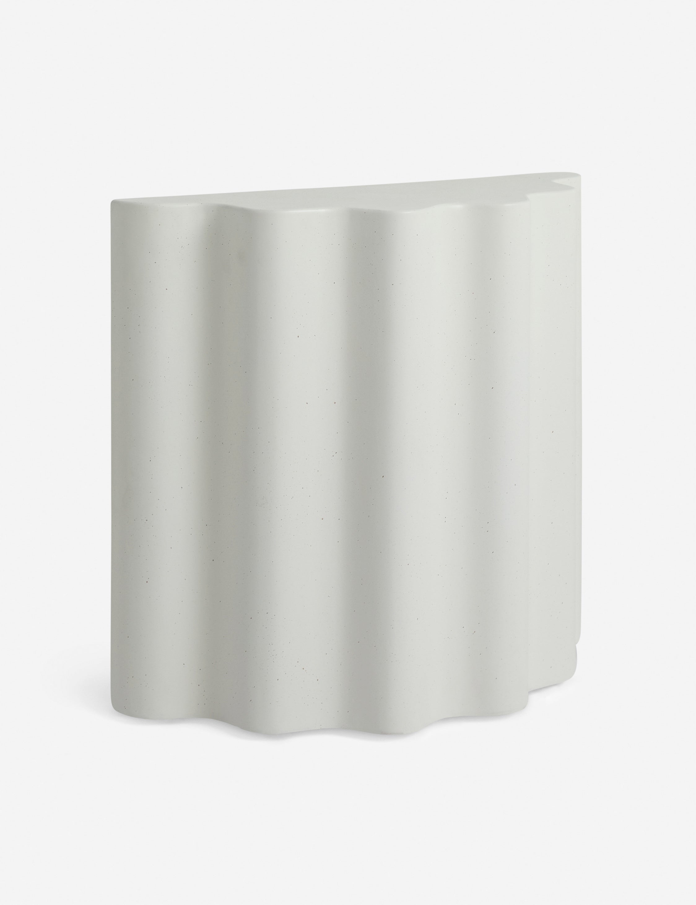 Angled view of the Lune half-moon, scalloped concrete side table