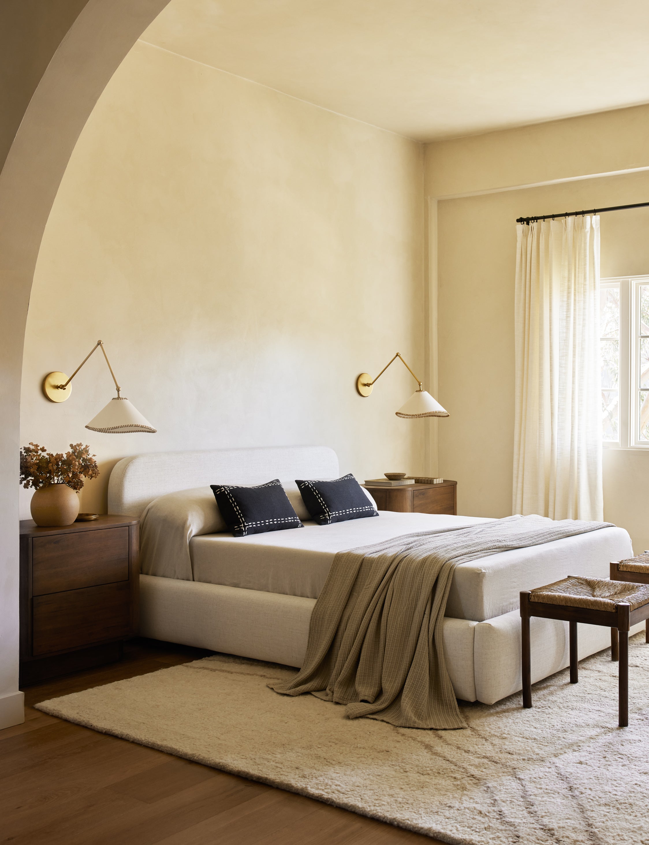TwoArroyo Mixed-Material Adjustable Arm Sconces by Elan Byrd mounted above the nightstands in a bedroom.