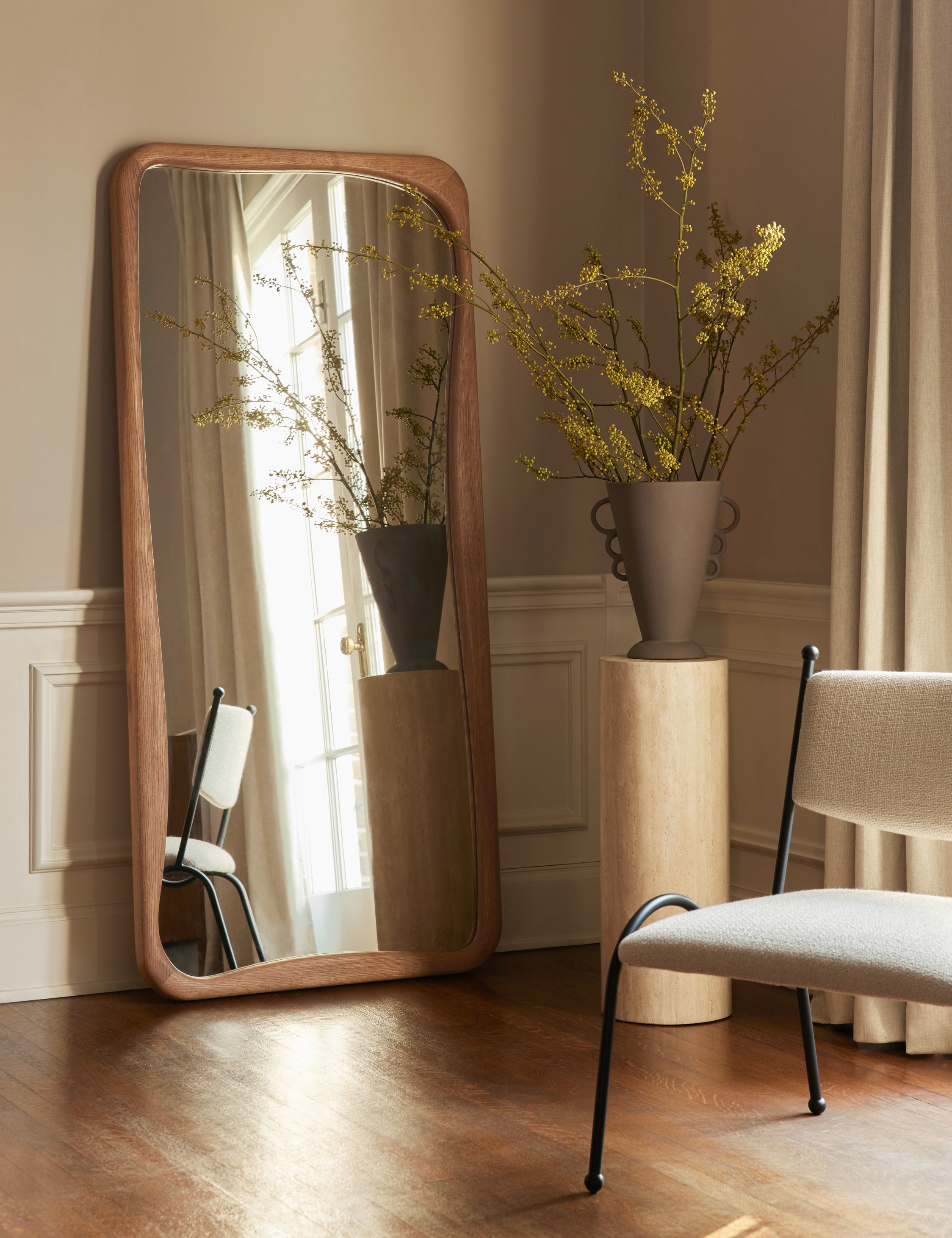 Panthea textural tapered loop handle ceramic vase by Aimee Song styled on a pedestal next to a floor mirror