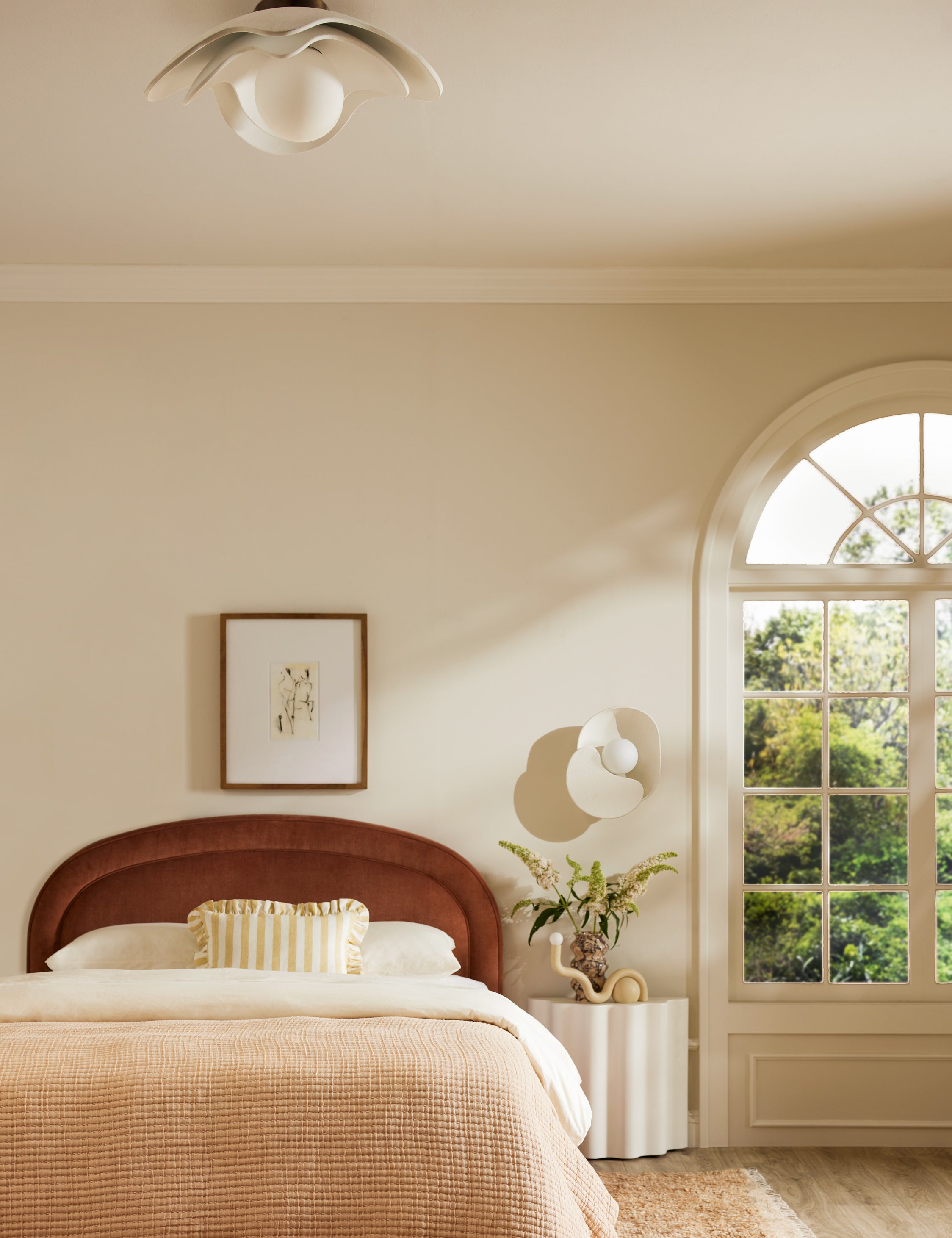 Soft Petal matte white floral silhouette flush mount light hung above a bed in a bedroom