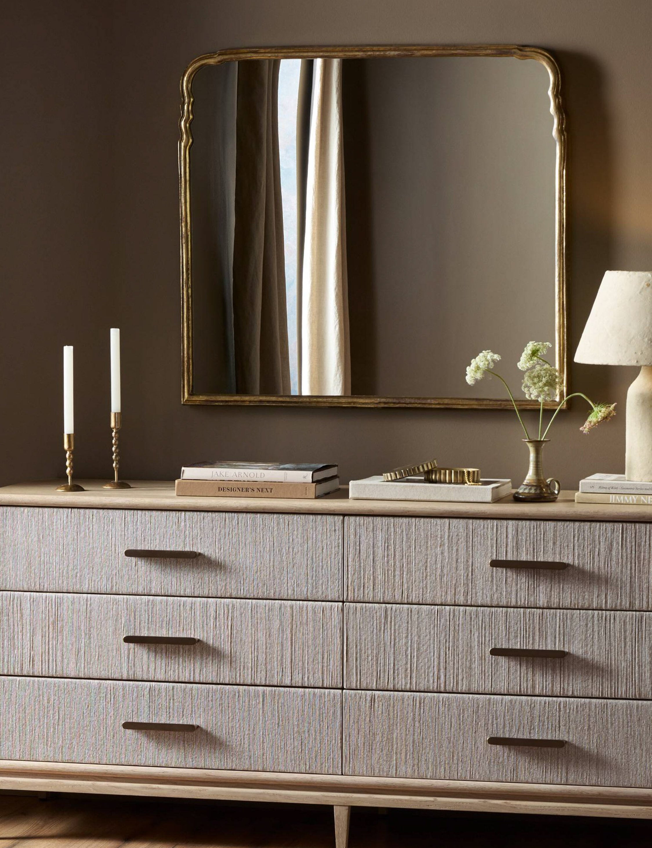Coudray serpentine gold leaf frame mantel mirror hung above a dresser