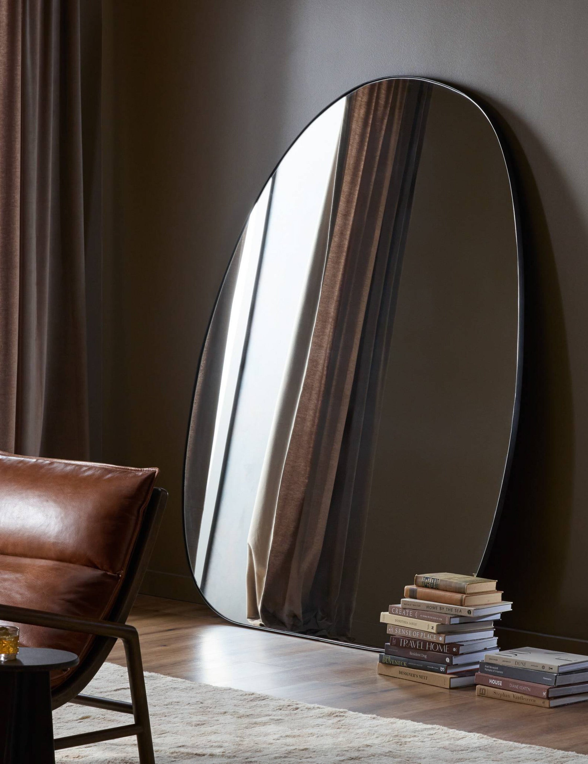 Platero modern oval leaning floor mirror against a wall