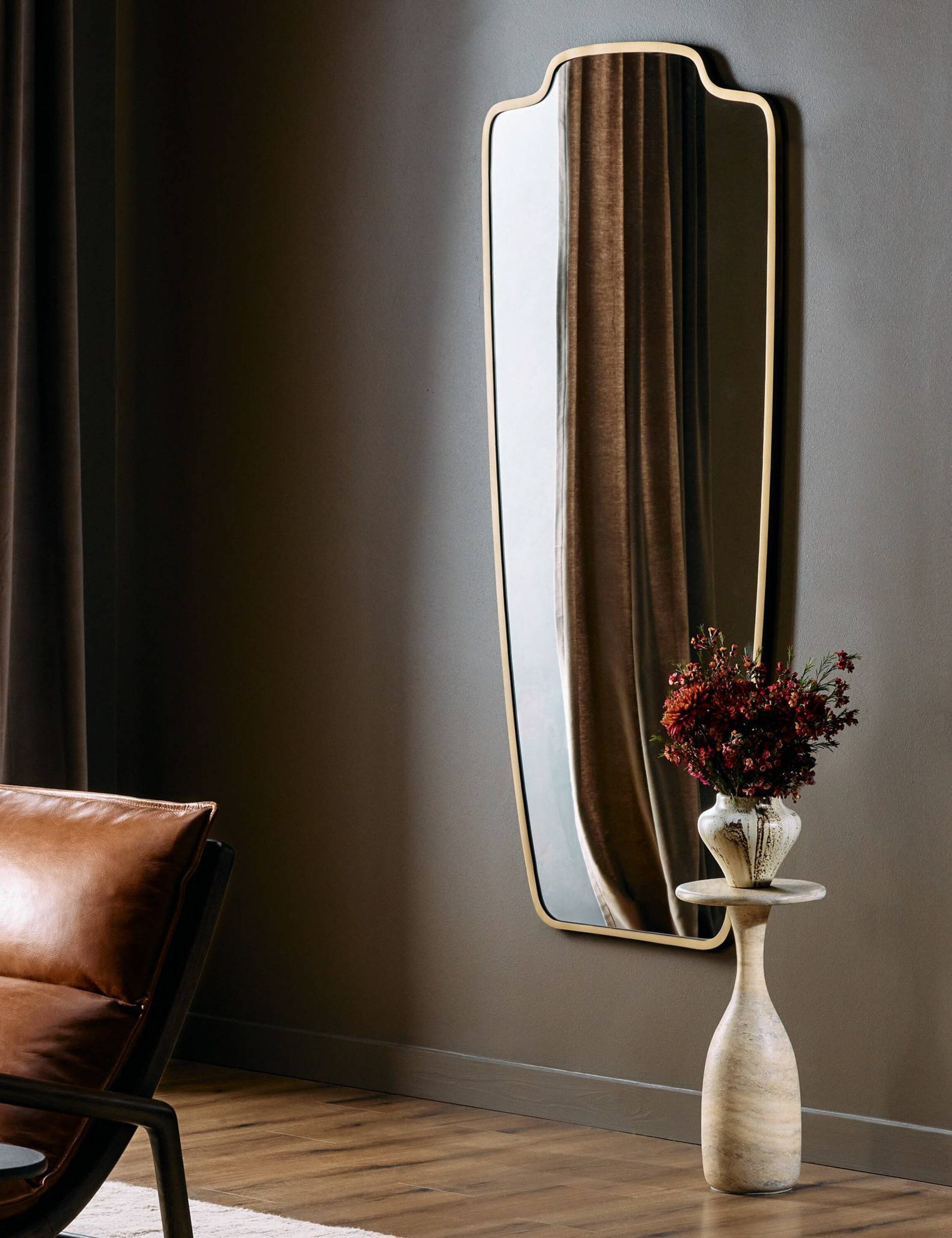 Armond crest-shaped slim frame full length mirror hung on a wall