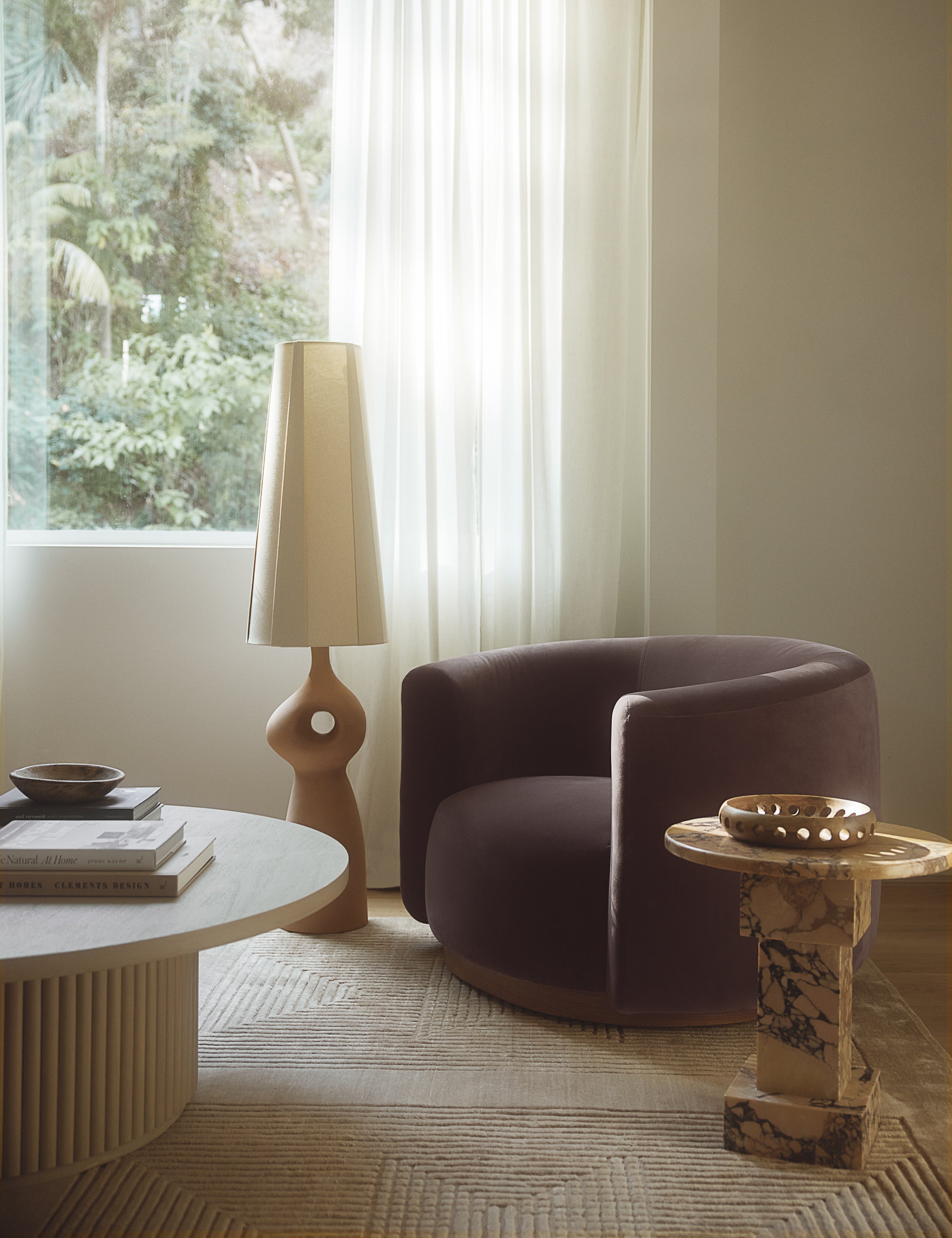 Potts round marble pedestal side table styled with a round velvet accent chair.