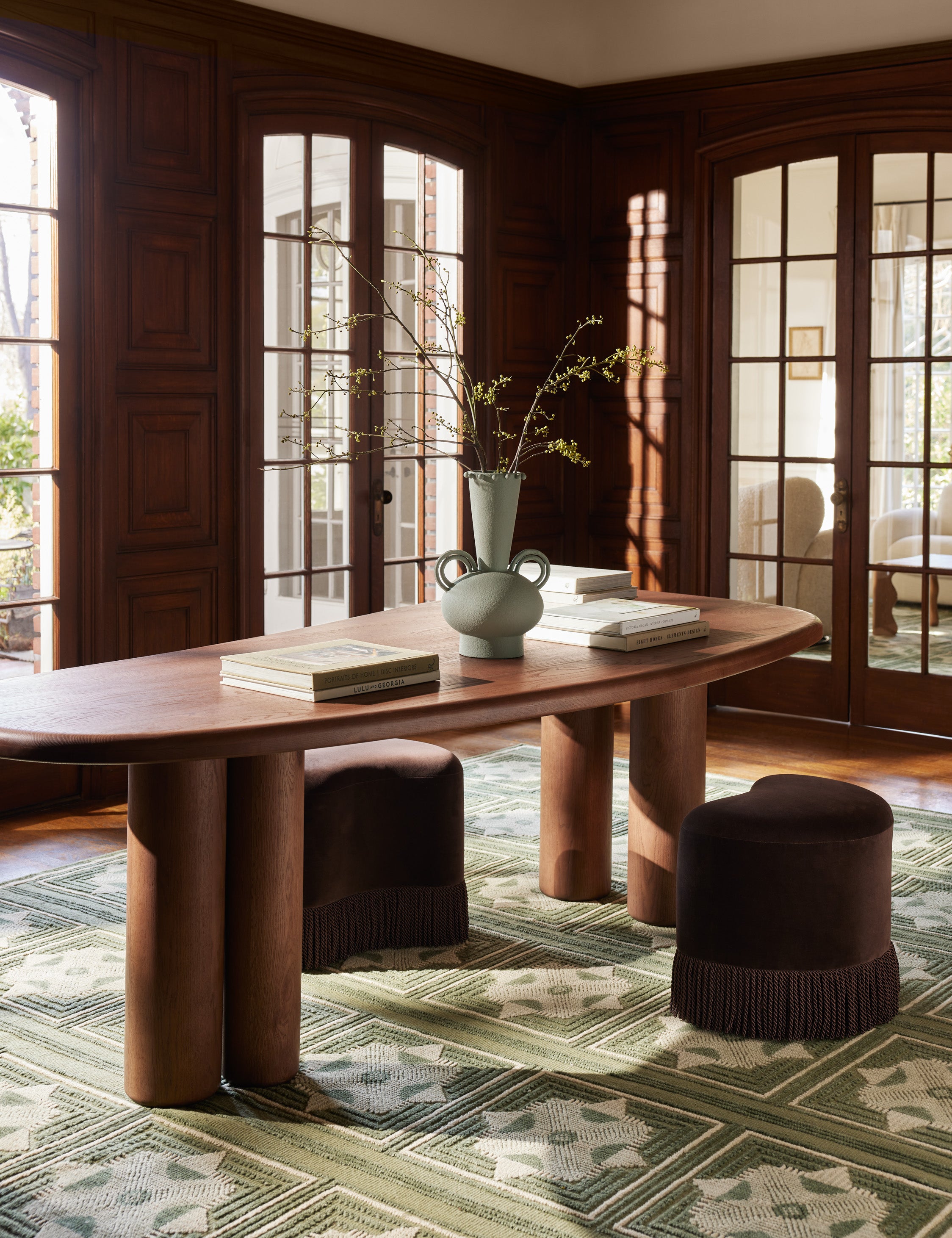 Nave modern sculptural red oak dining table by Aimee Song styled with accent stools