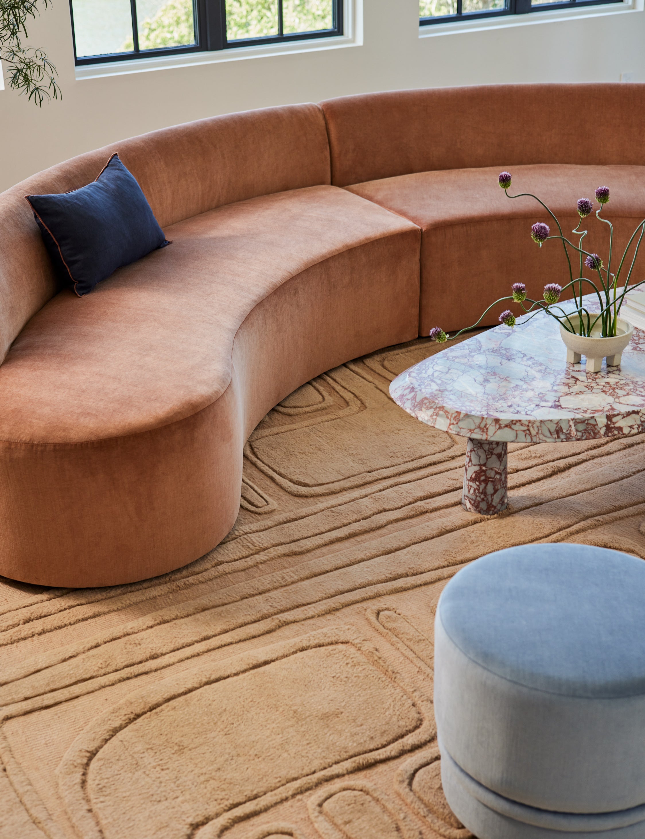 Bosa abstract design hand-knotted wool rug styled with a curved sofa and marble coffee table.