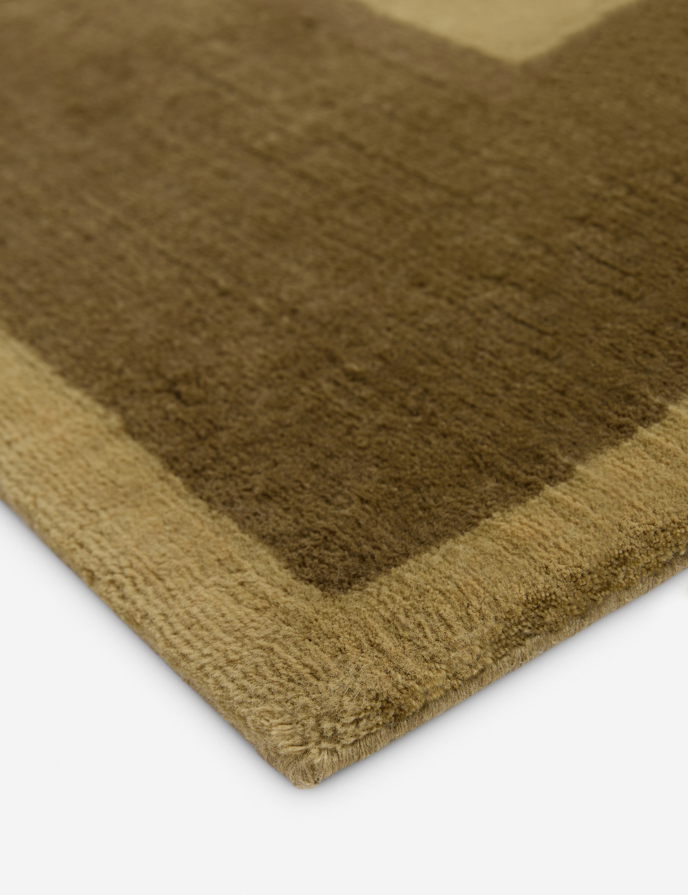 Close up of the corner of the Deller Hand-Loomed Wool Rug by Jake Arnold