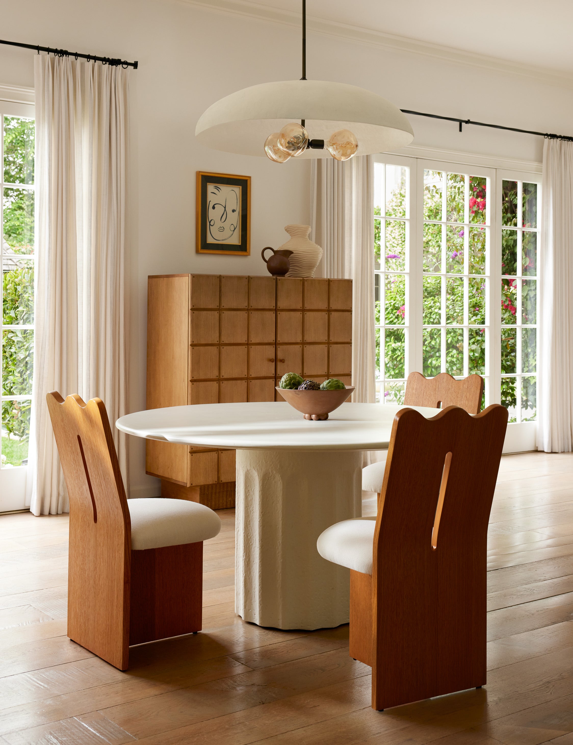 Three Ripple tall, wavy back wooden dining chair around a dining table