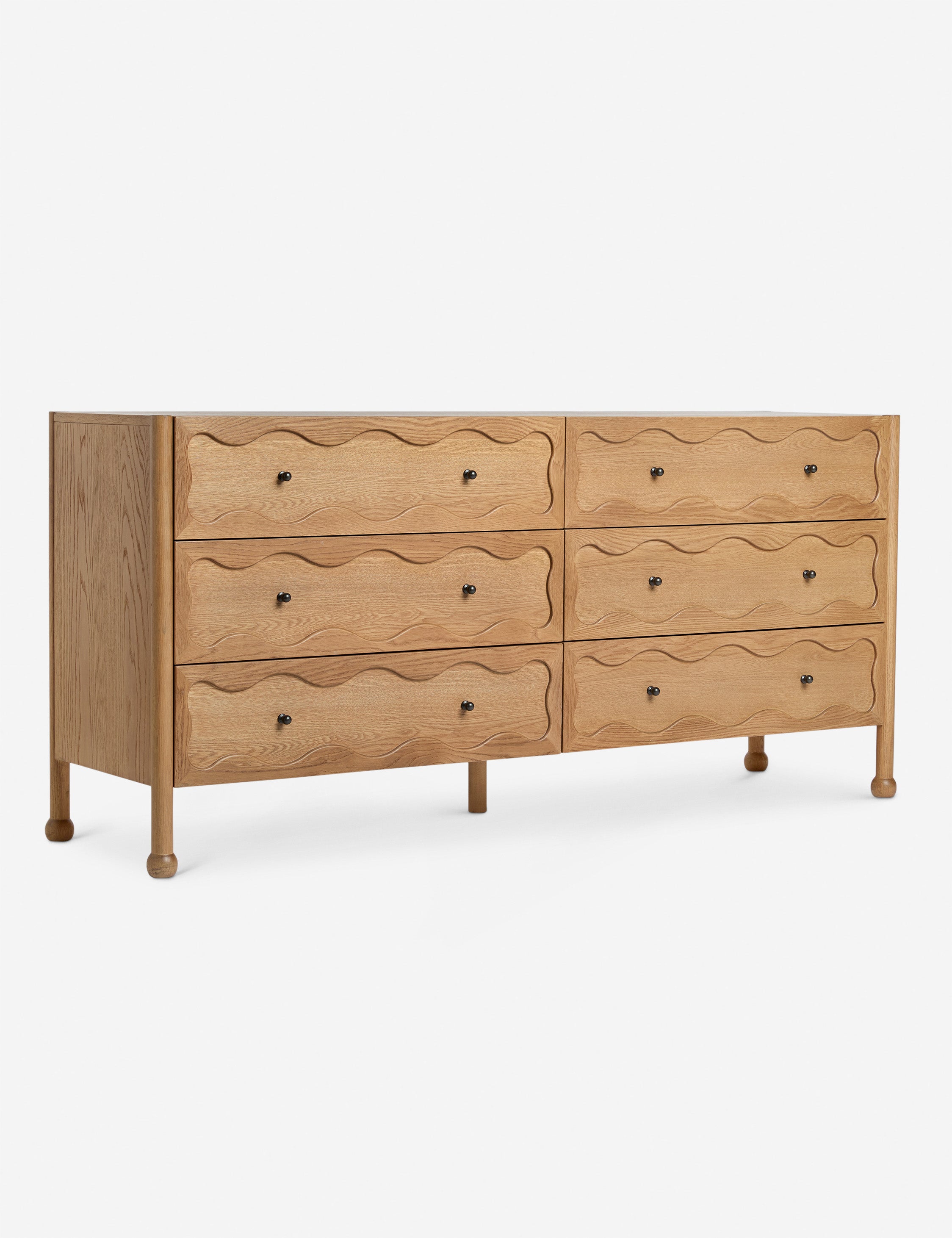 Angled view of the Fontaine wavy detailing solid oak 6-drawer dresser by Aimee Song