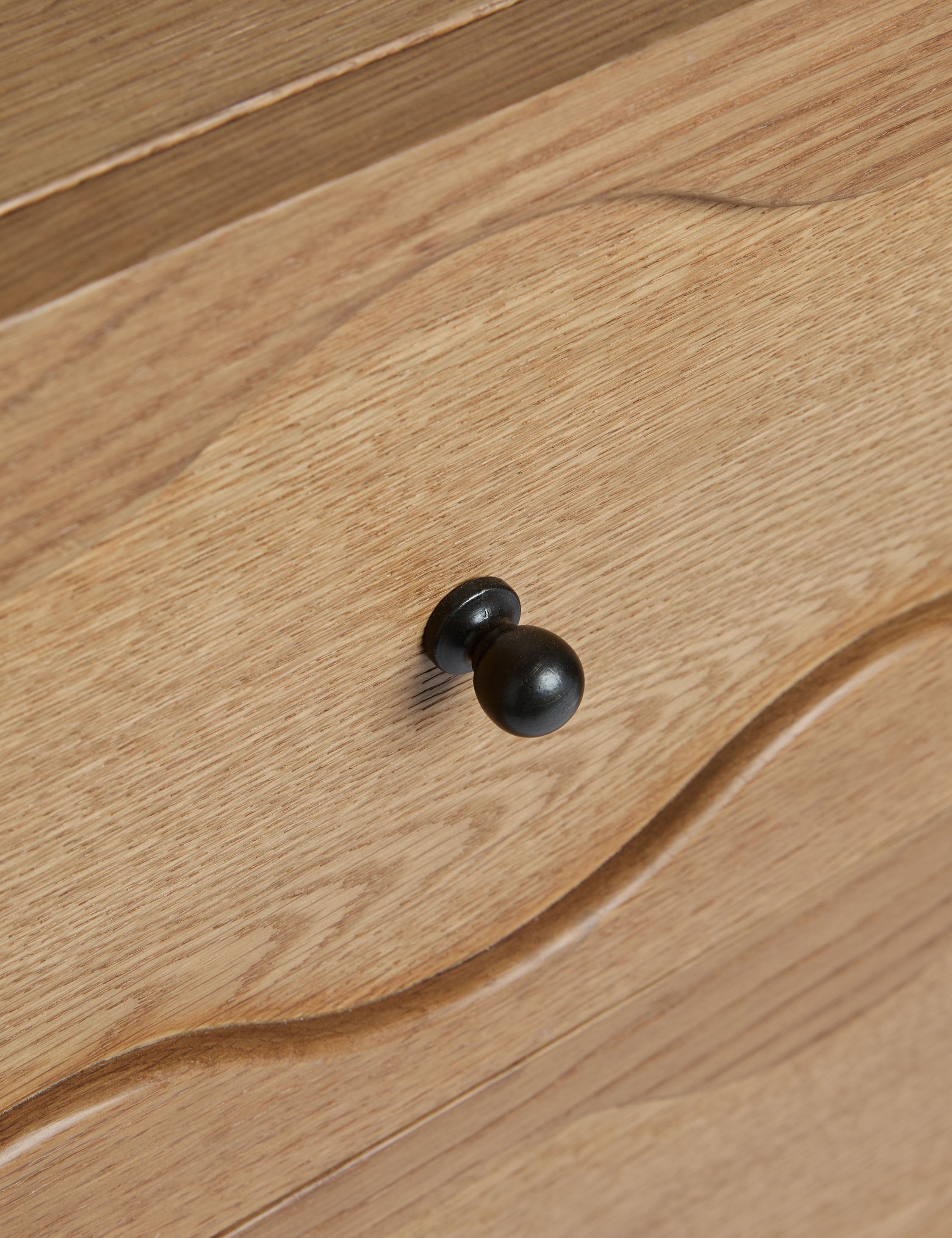 Close up of the drawer pull of the Fontaine wavy detailing solid oak 6-drawer dresser by Aimee Song