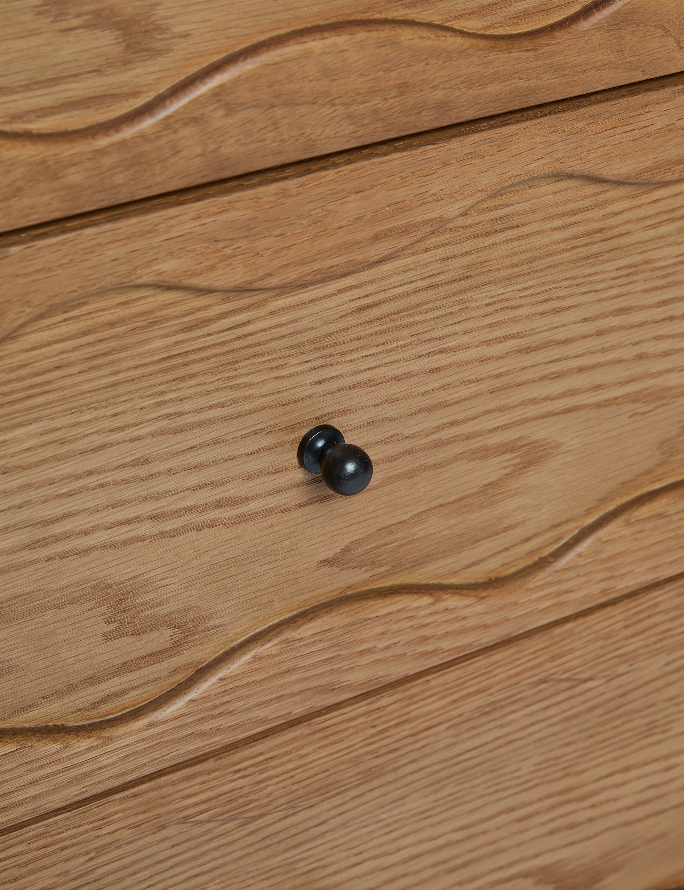 Close up view of the drawer pull of the Fontaine wavy detailing solid oak sideboard by Aimee Song