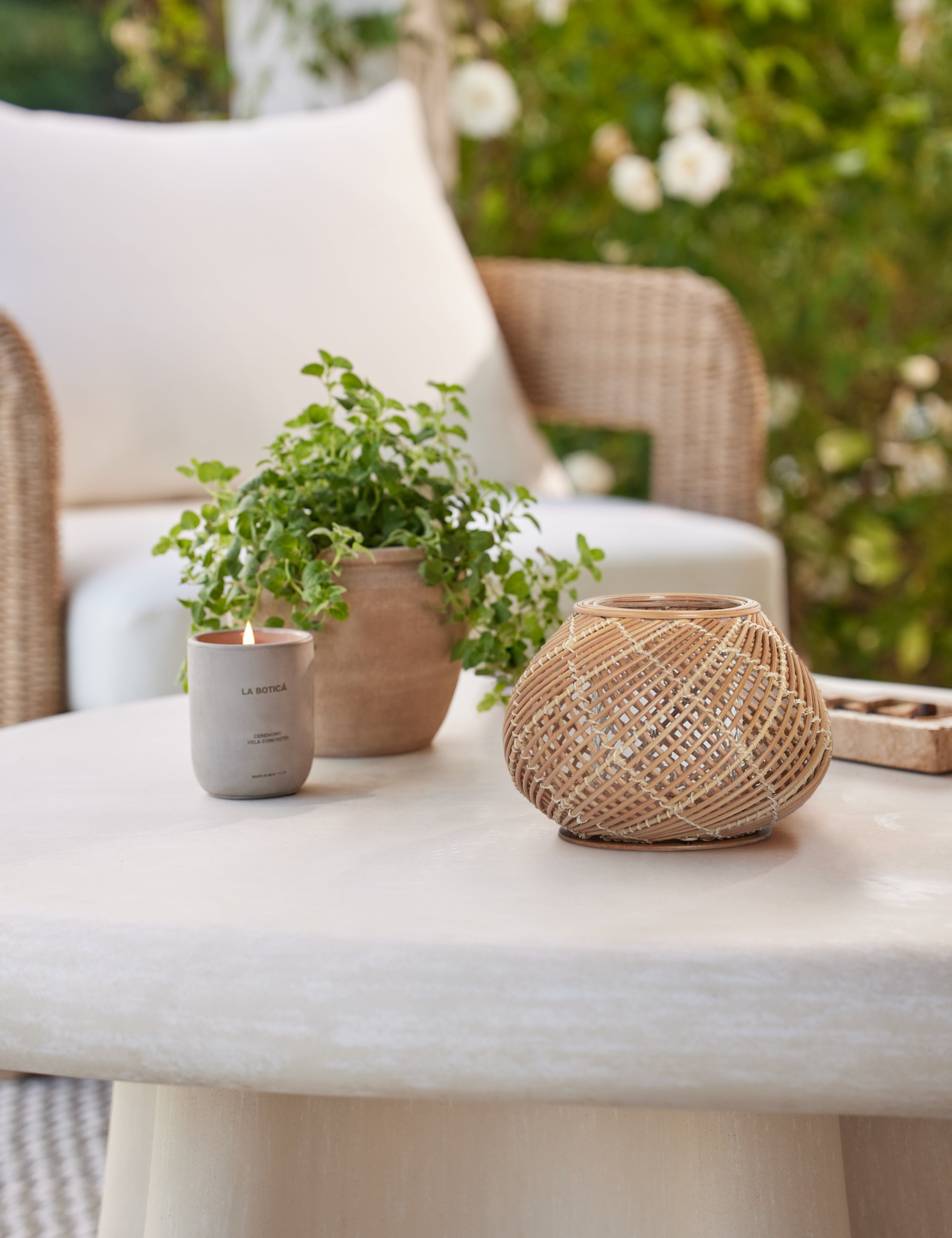 Argos small modern woven lantern candleholder on an outdoor coffee table.