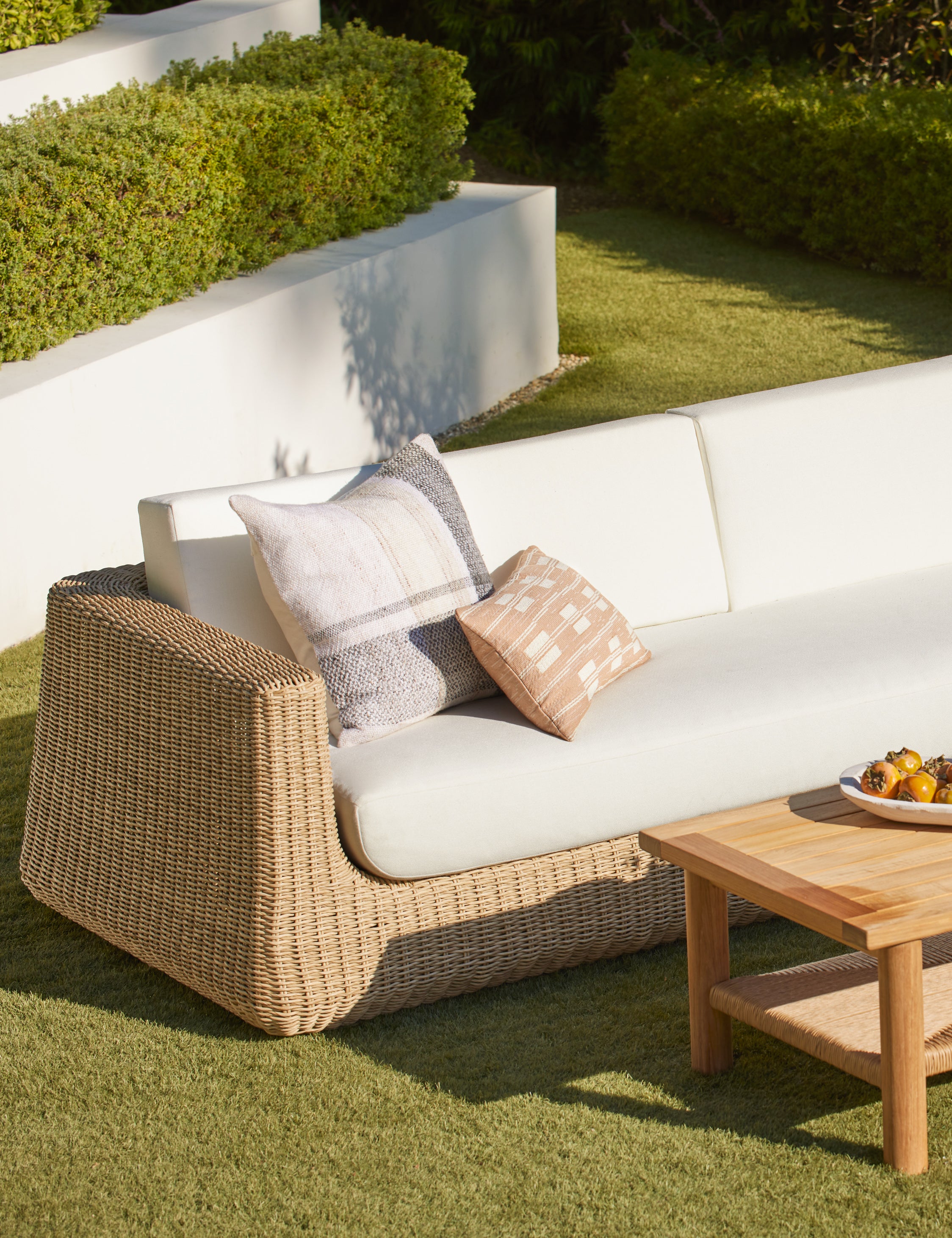 Leighton broken stripe lumbar pillow in terracotta styled on an outdoor sofa.