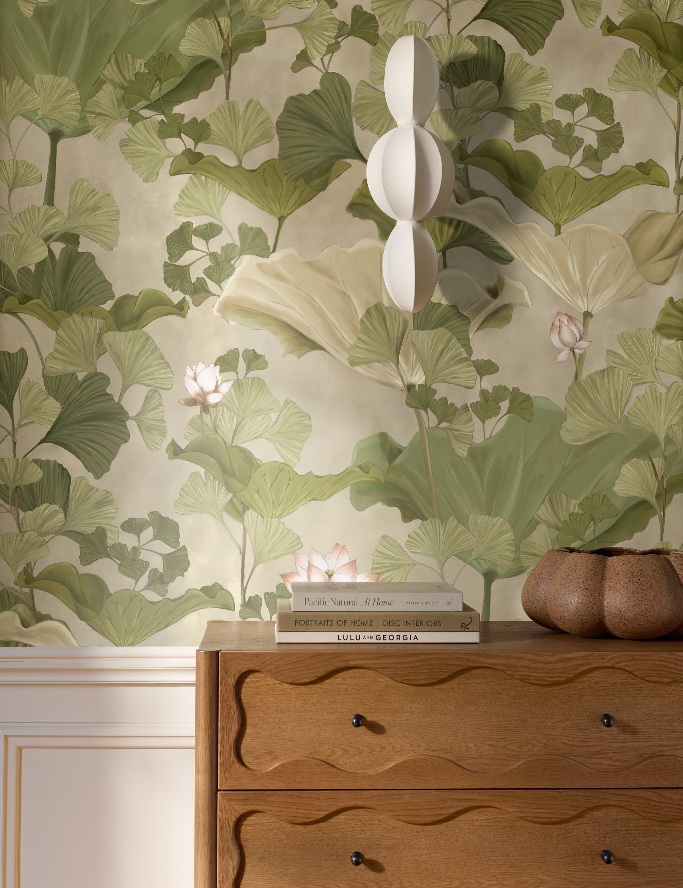 Lotus lush botanical wallpaper by Aimee Song on a wall behind a dresser