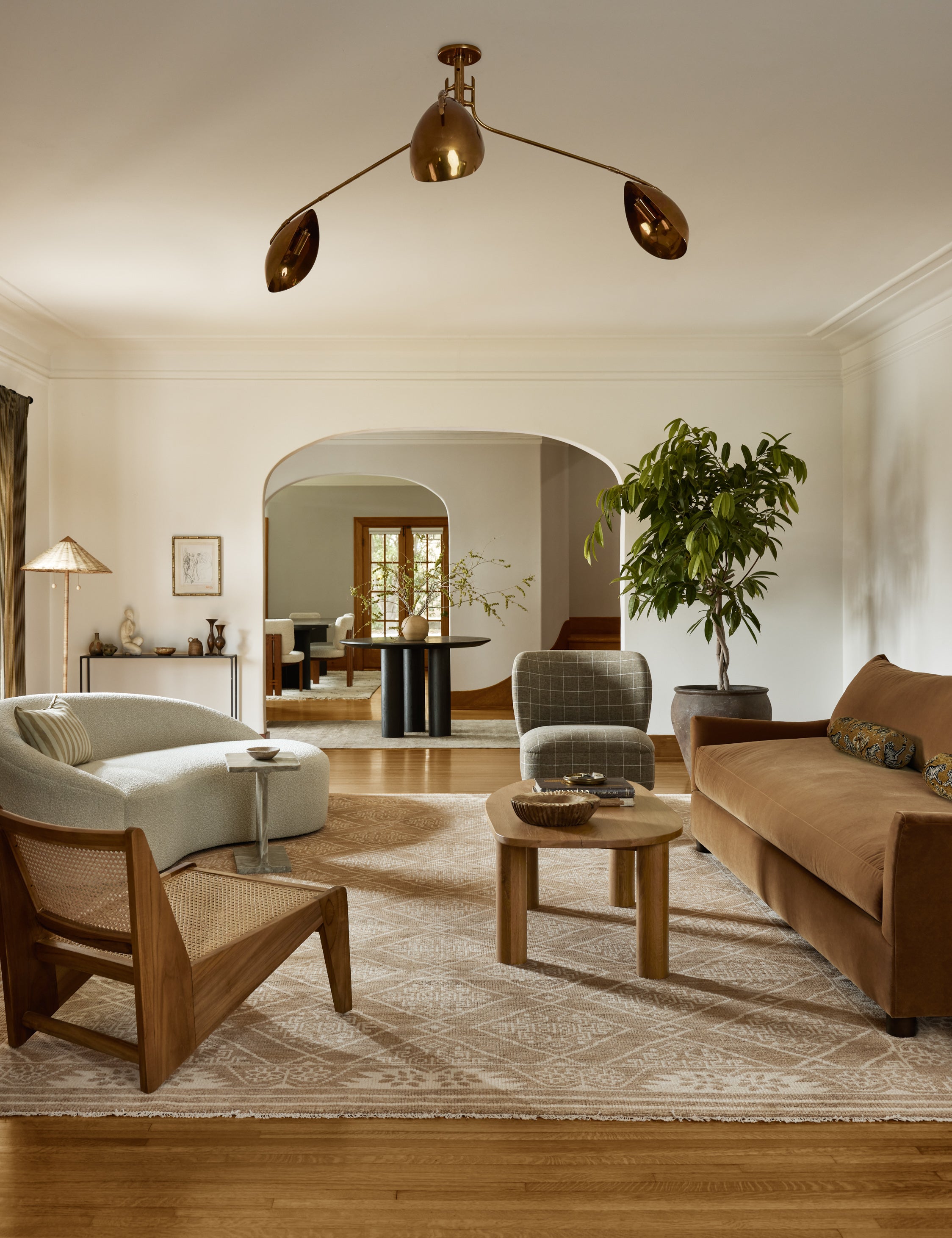 A living room featuring the Abanu mid-century adjustable brass chandelier.