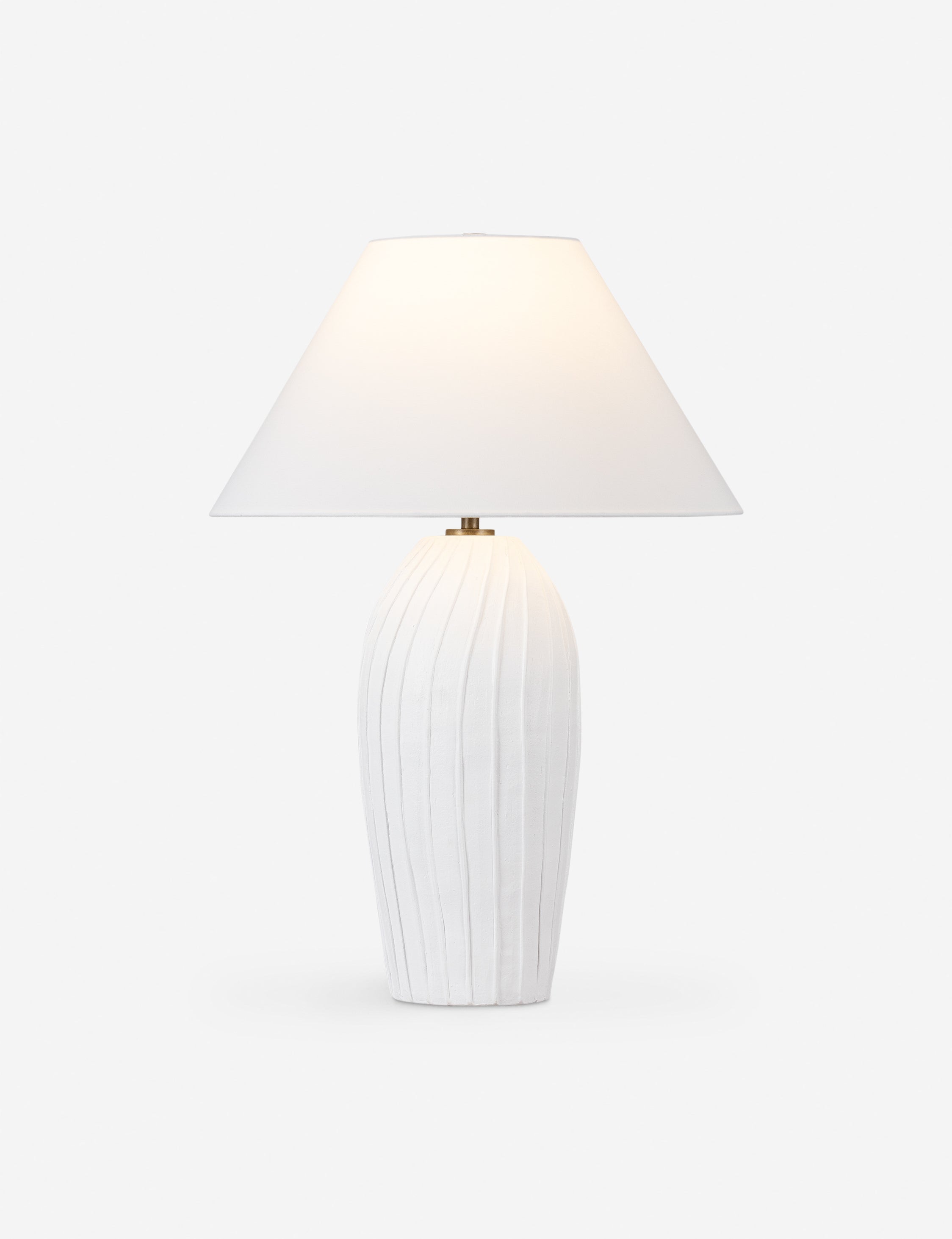 Pama sculptural, pleated-detail ceramic table lamp with the light on