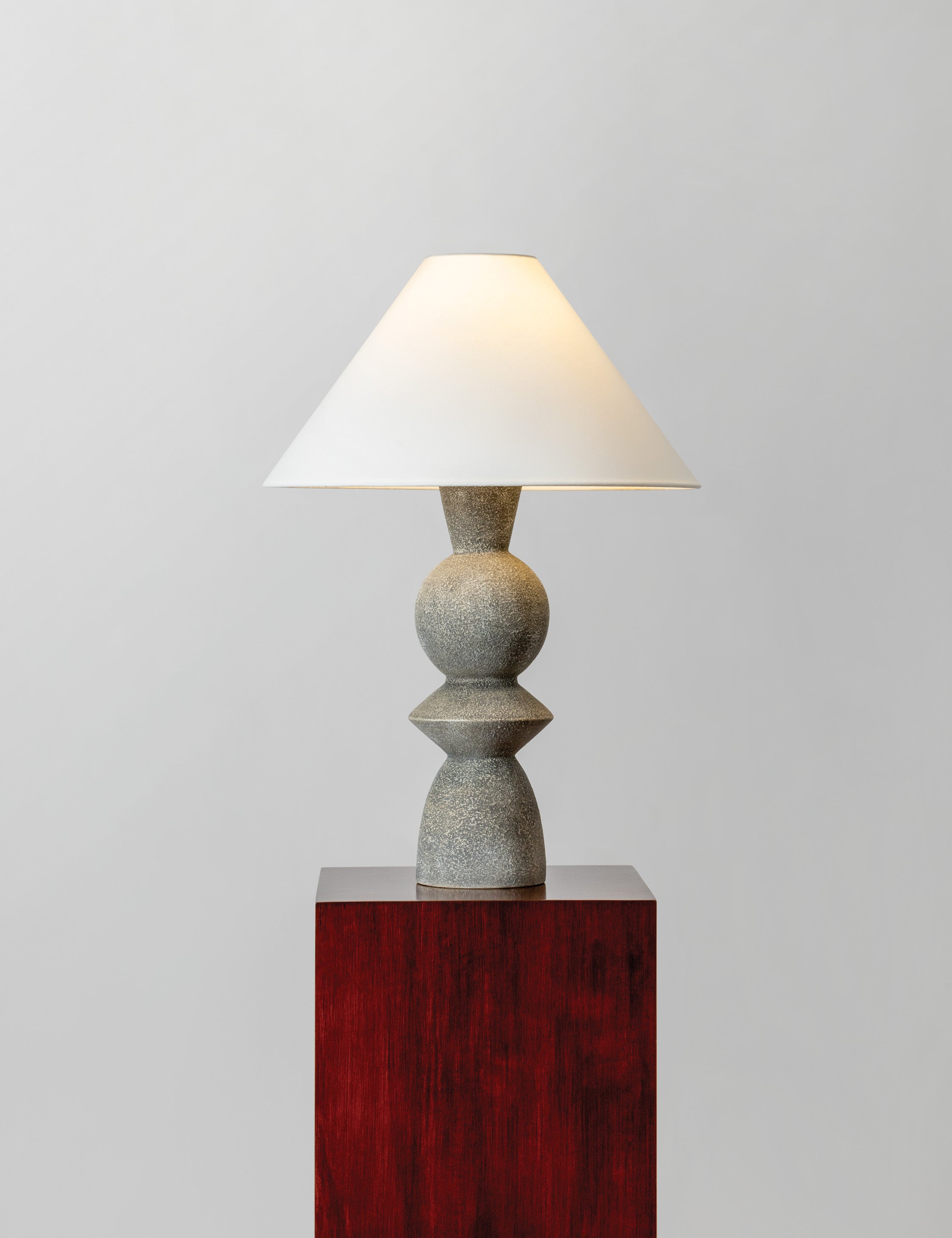 Bulsara geometric, stone-finish ceramic table lamp with the light on