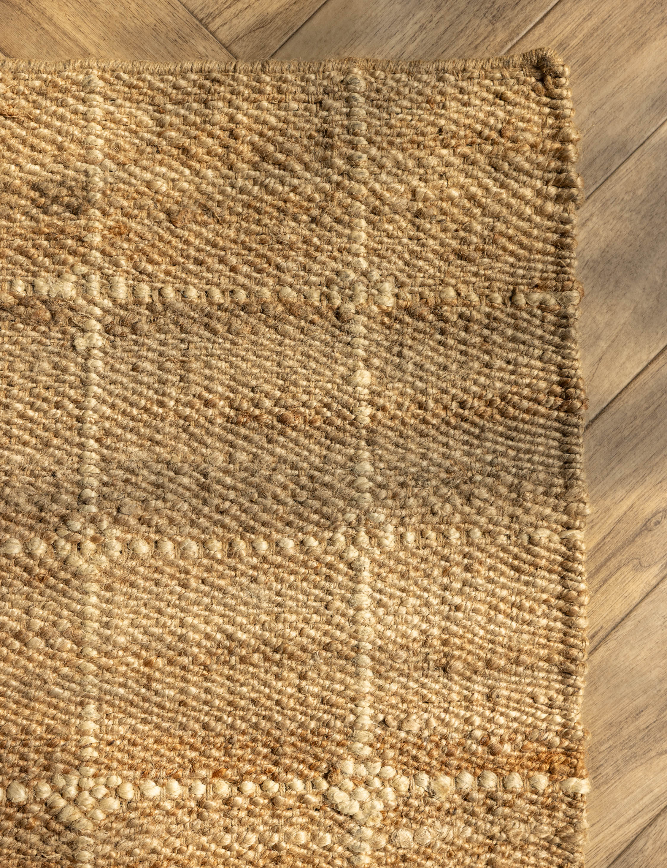 Close up of the corner of the Beddow Flatweave Jute Grid Rug by Jake Arnold.