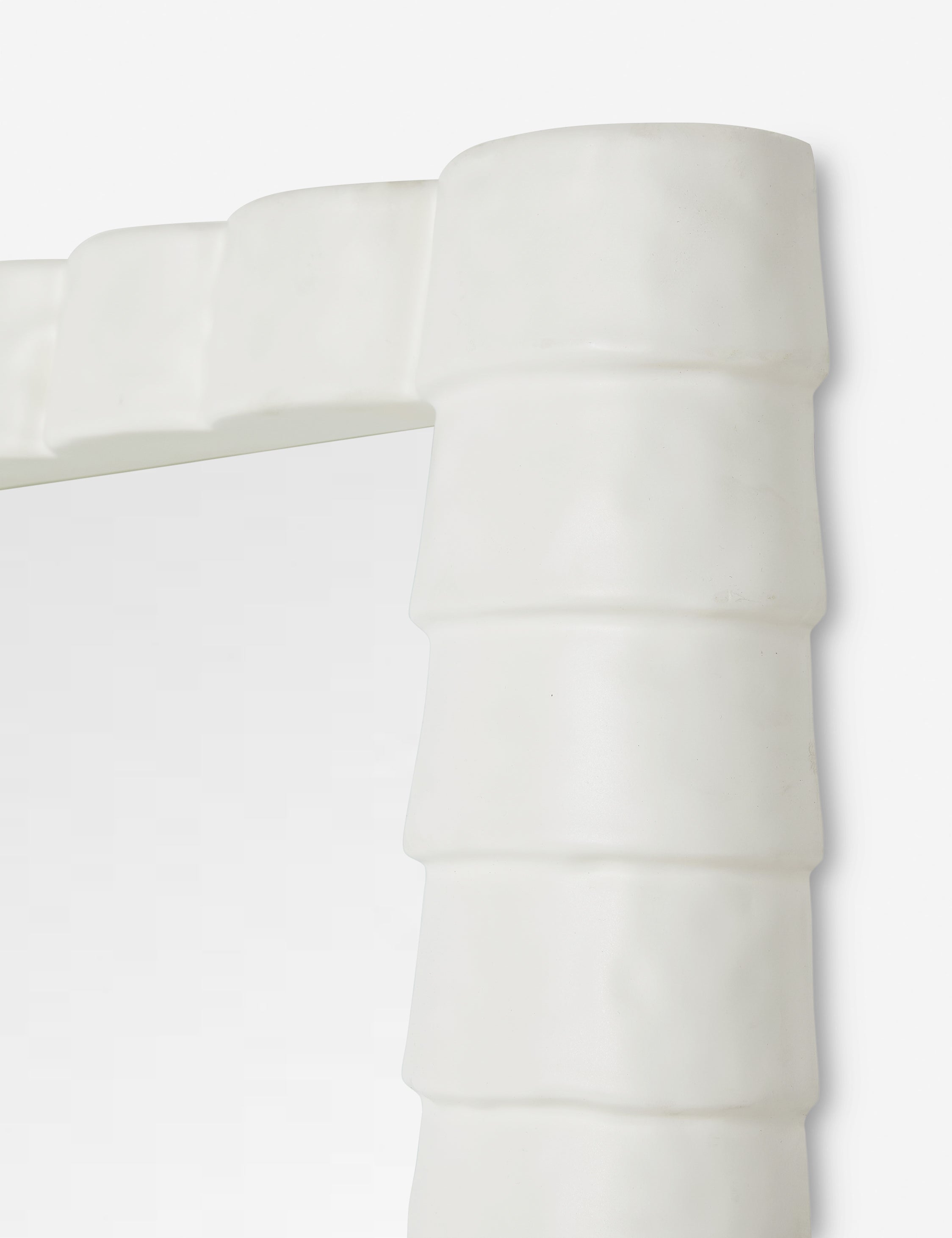 Top corner of the Munro white sculptural modern floor mirror.