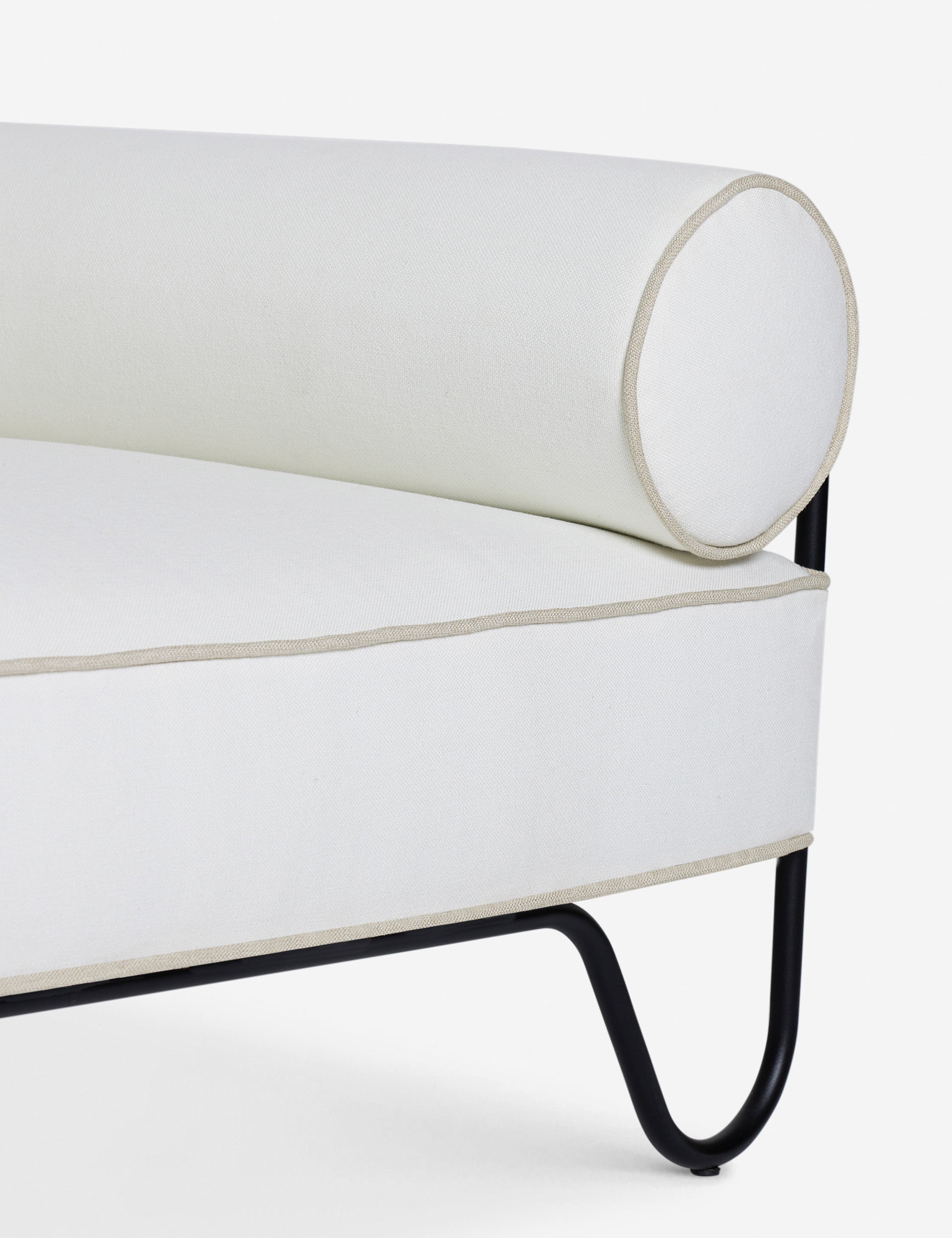 Close up of the Peggy sculptural iron frame and white cushion outdoor accent chair.
