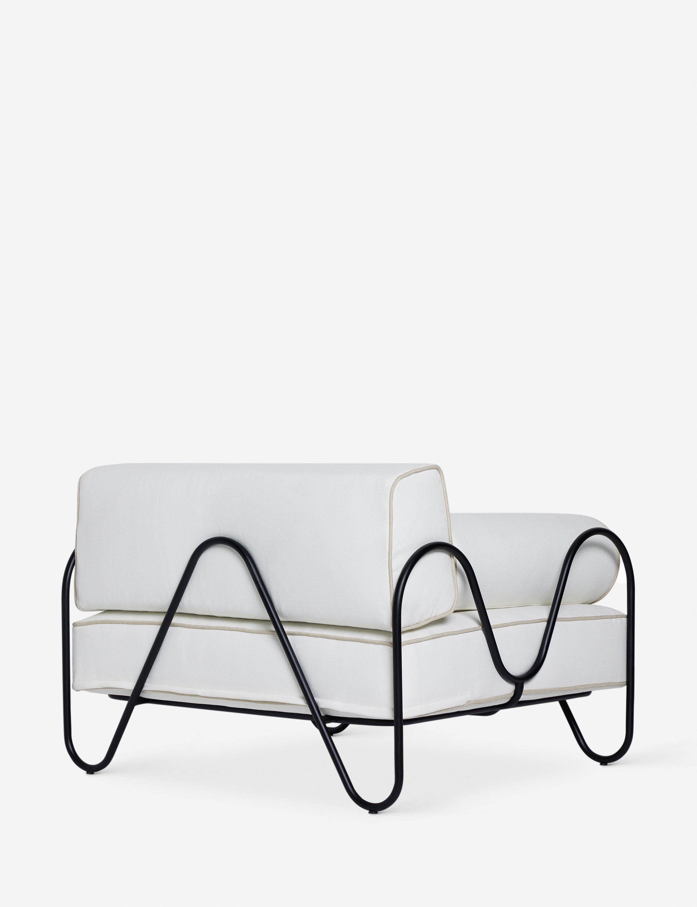 Angled back view of the Peggy sculptural iron frame and white cushion outdoor accent chair.