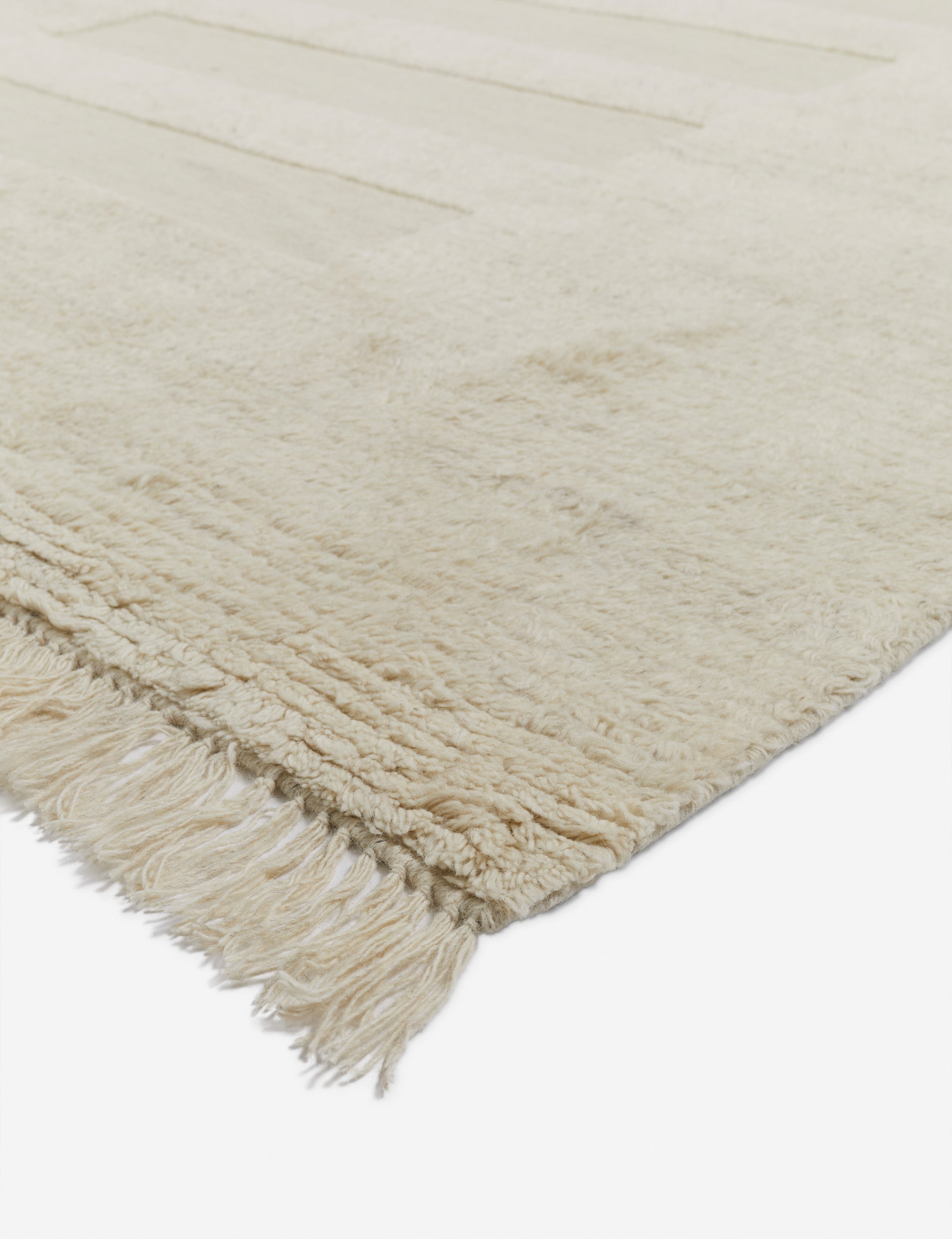 Corner of the Raita subtle bar patter fringe area rug in ivory