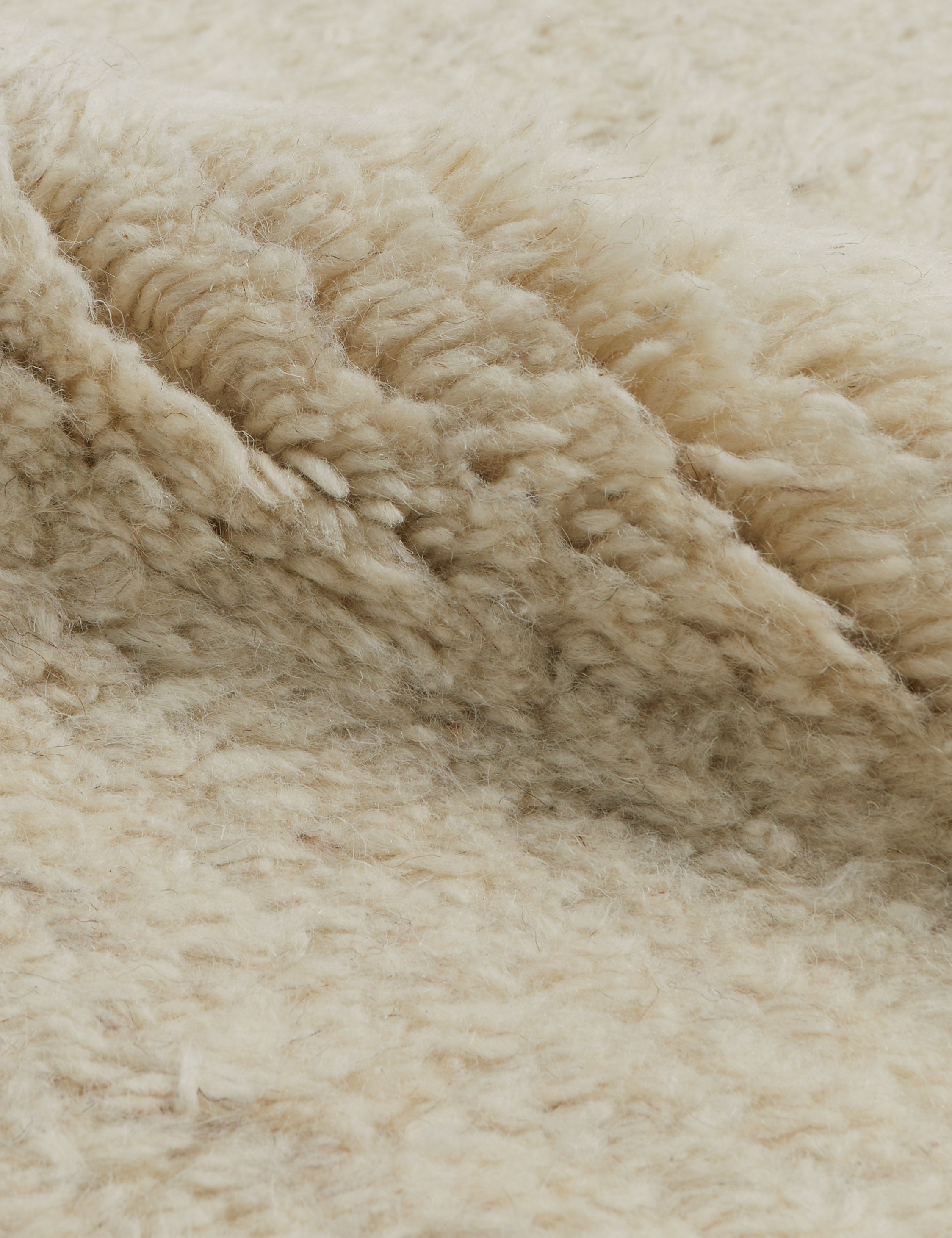 Close up view of the Raita subtle bar patter fringe area rug in ivory