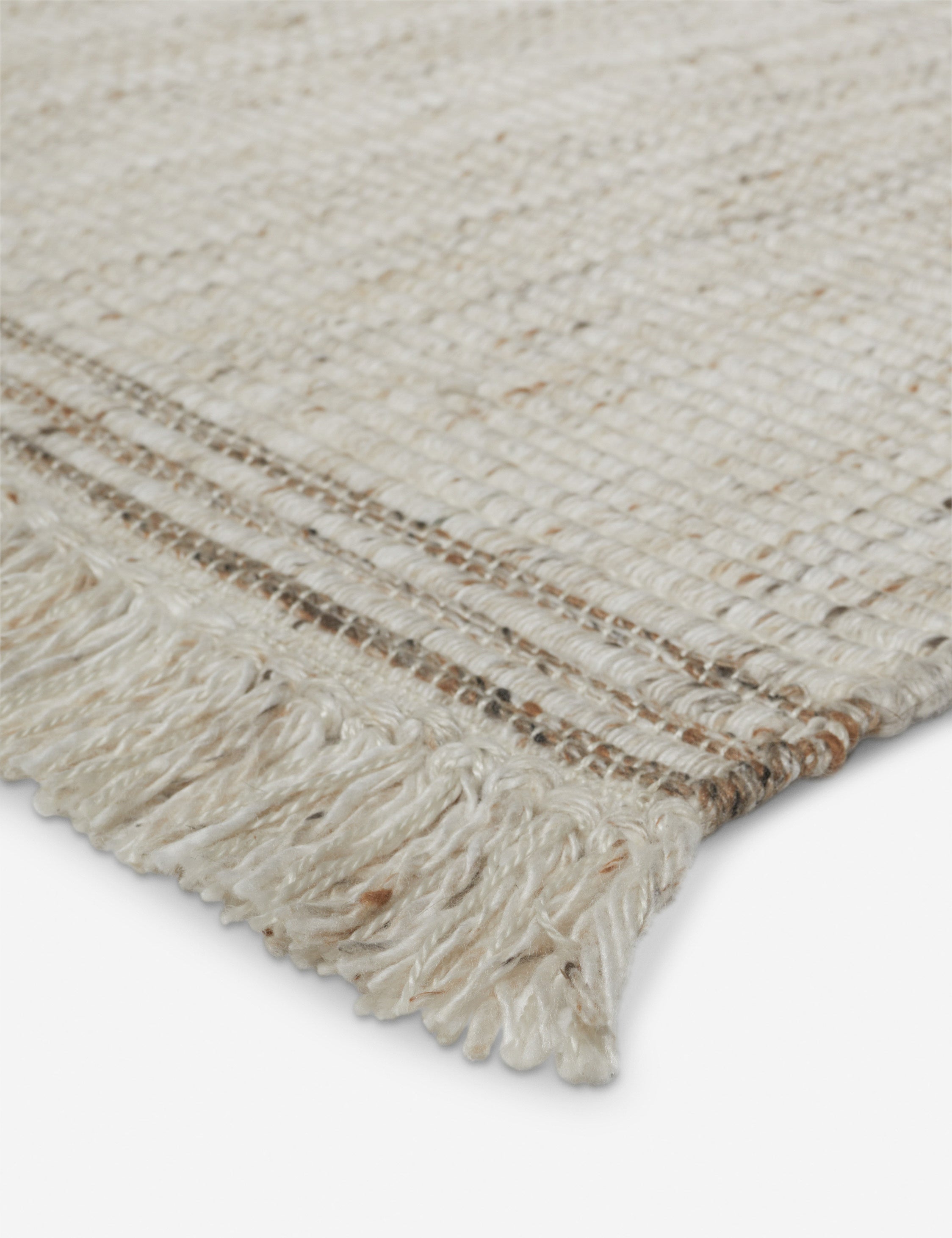 Close up of the fringe of the Sabriel handwoven large-scale striped fringed outdoor rug.