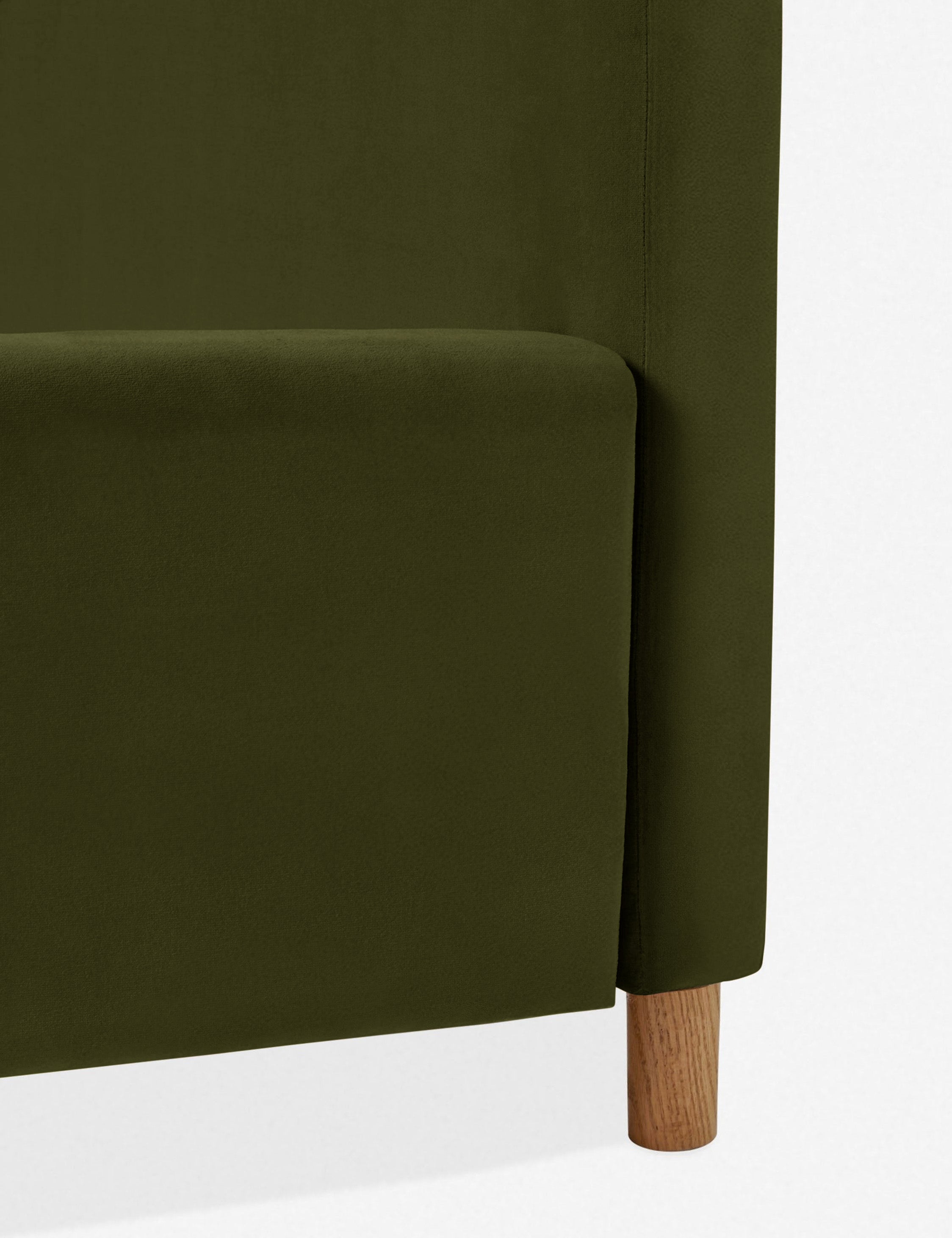 Close-up of where the headboard, oak leg, and base of the Solene Loden Velvet platform bed meet