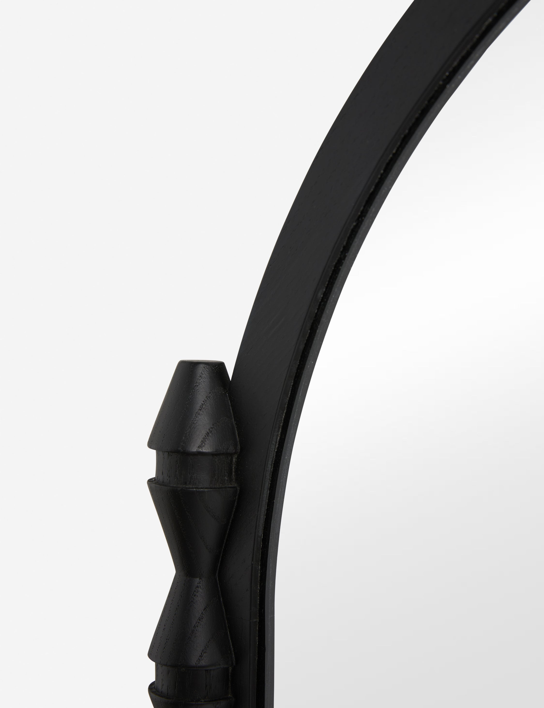 Close up of the Topia arched carved wood mantel mirror by Ginny Macdonald in black.