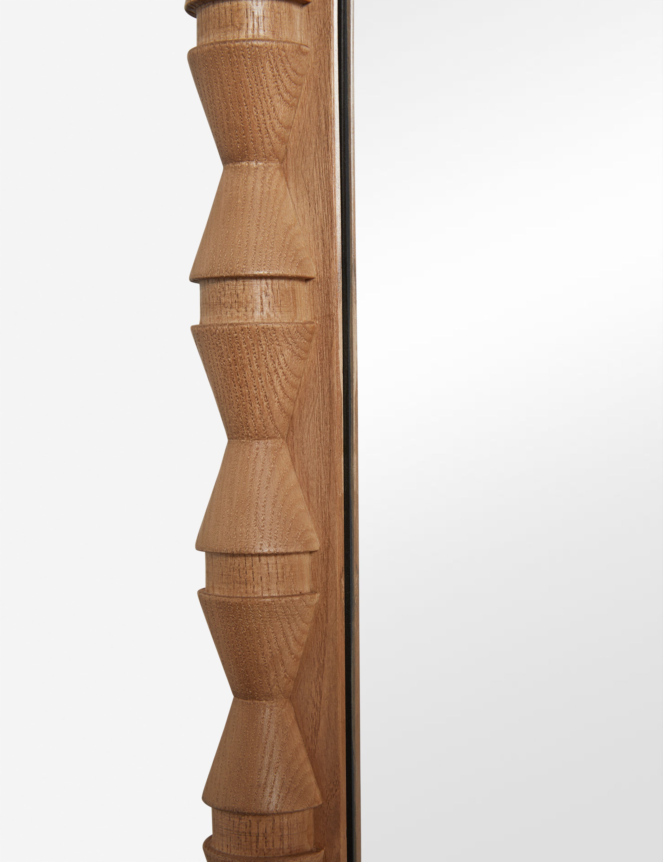 Close up of the frame details of the Topia arched carved wood mantel mirror by Ginny Macdonald in natural.