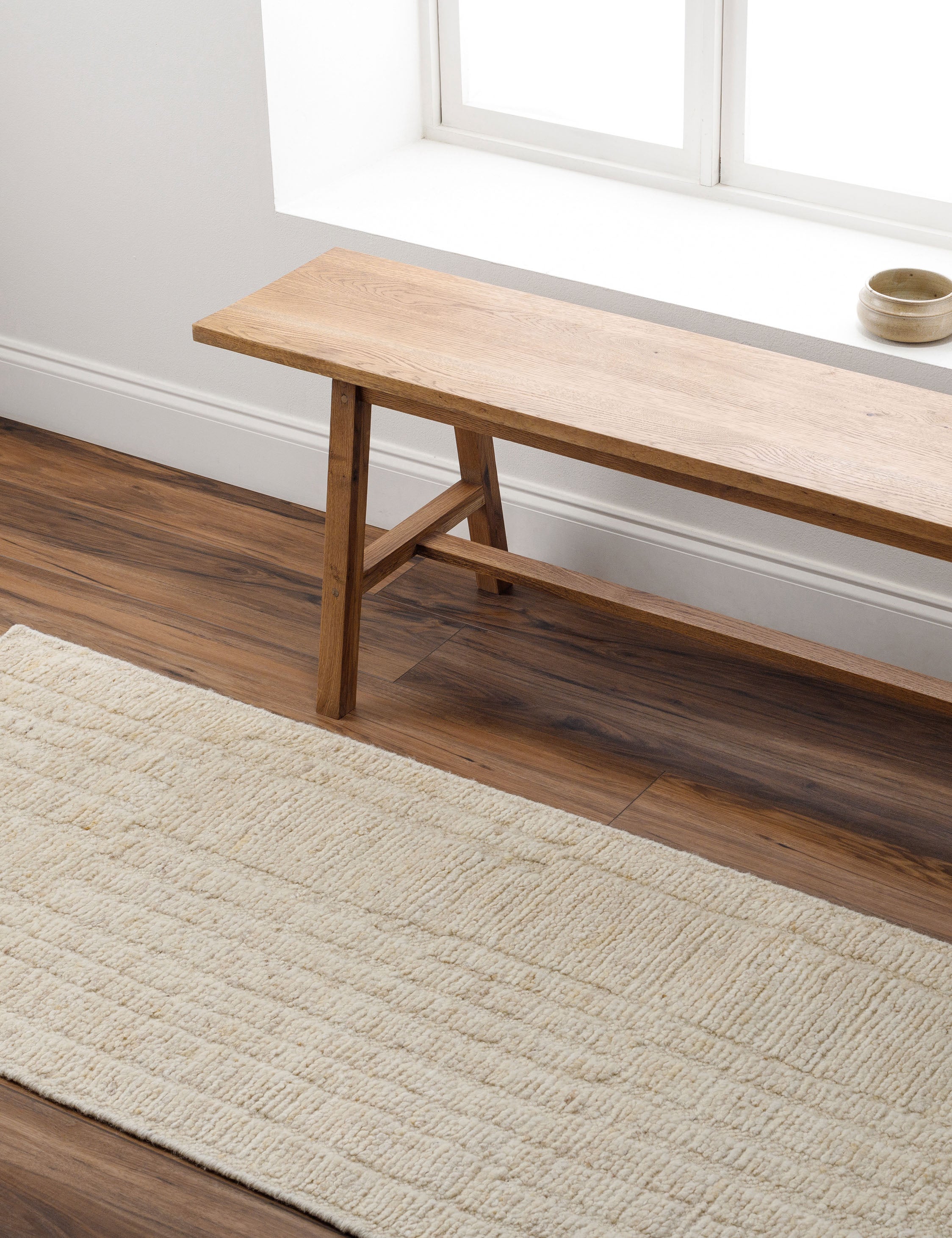 Malone textured ivory hand-knotted wool runner rug styled in an entryway with bench