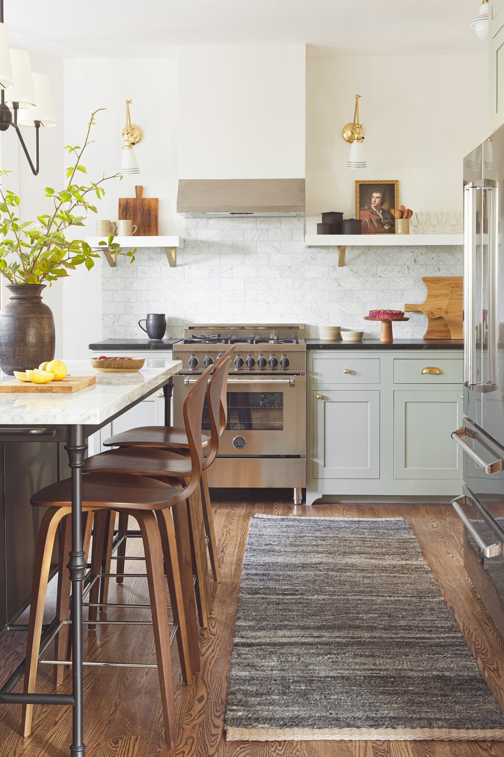 The Khloe charcoal rug in its runner size lays in a kitchen with white and black countertops, bar stools, and stainless steel appliances