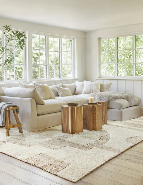 #size::6--x-9- #size::8--x-10- #size::9--x-12- #size::10--x-14- #size::12--x-15- | The Oasis plush geometric neutral-toned rug by Élan Byrd lays in a bright living room with a gray linen sofa, t-shaped wooden side tables, and neutral-toned throw pillows