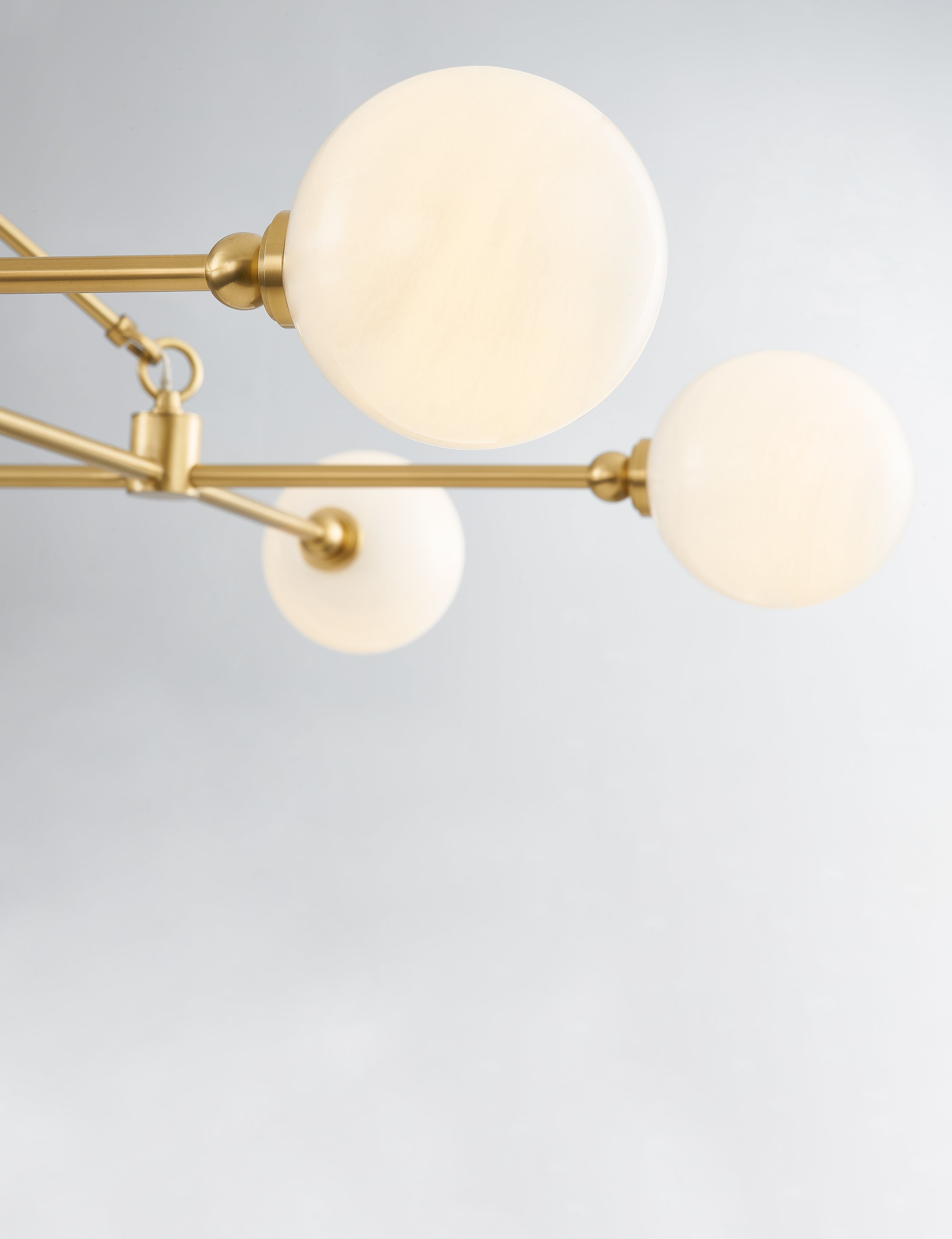 Close up of the glass shade of the Helia slim frame modern brass chandelier.